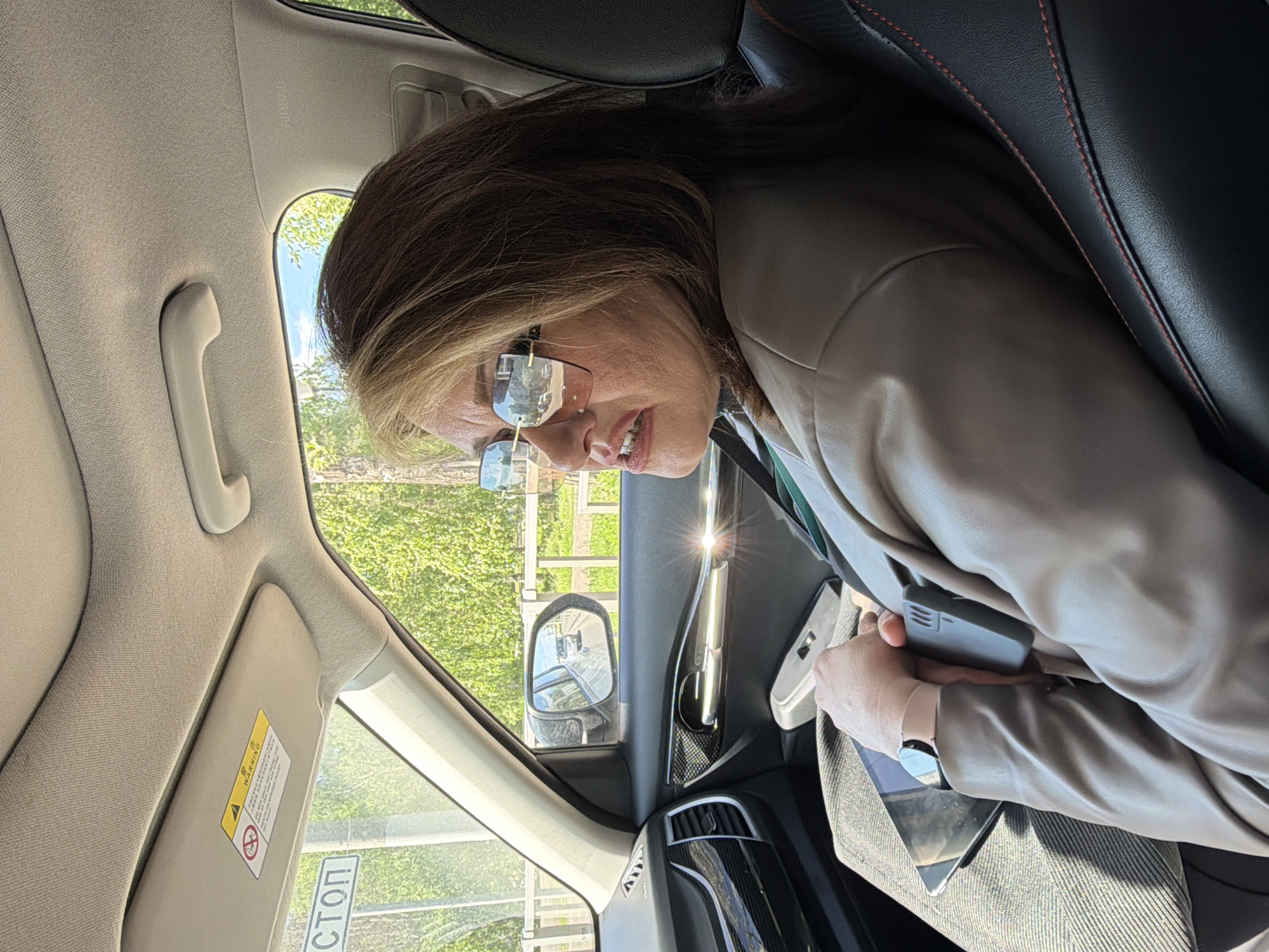 Woman uses phone and tablet inside car in Krasnoyarsk