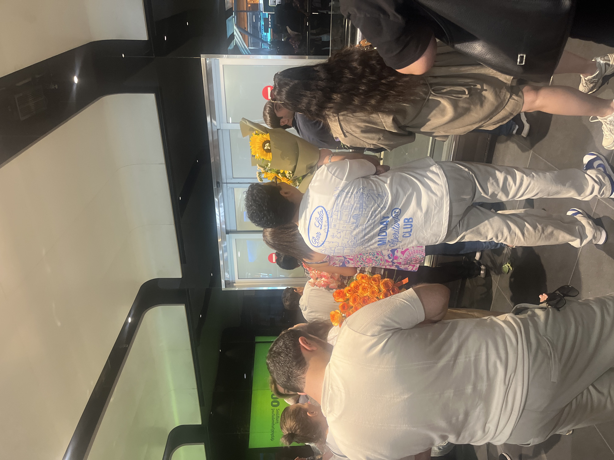 Arrivals crowd gathers at Yerevan's Zvartnots Airport with flowers