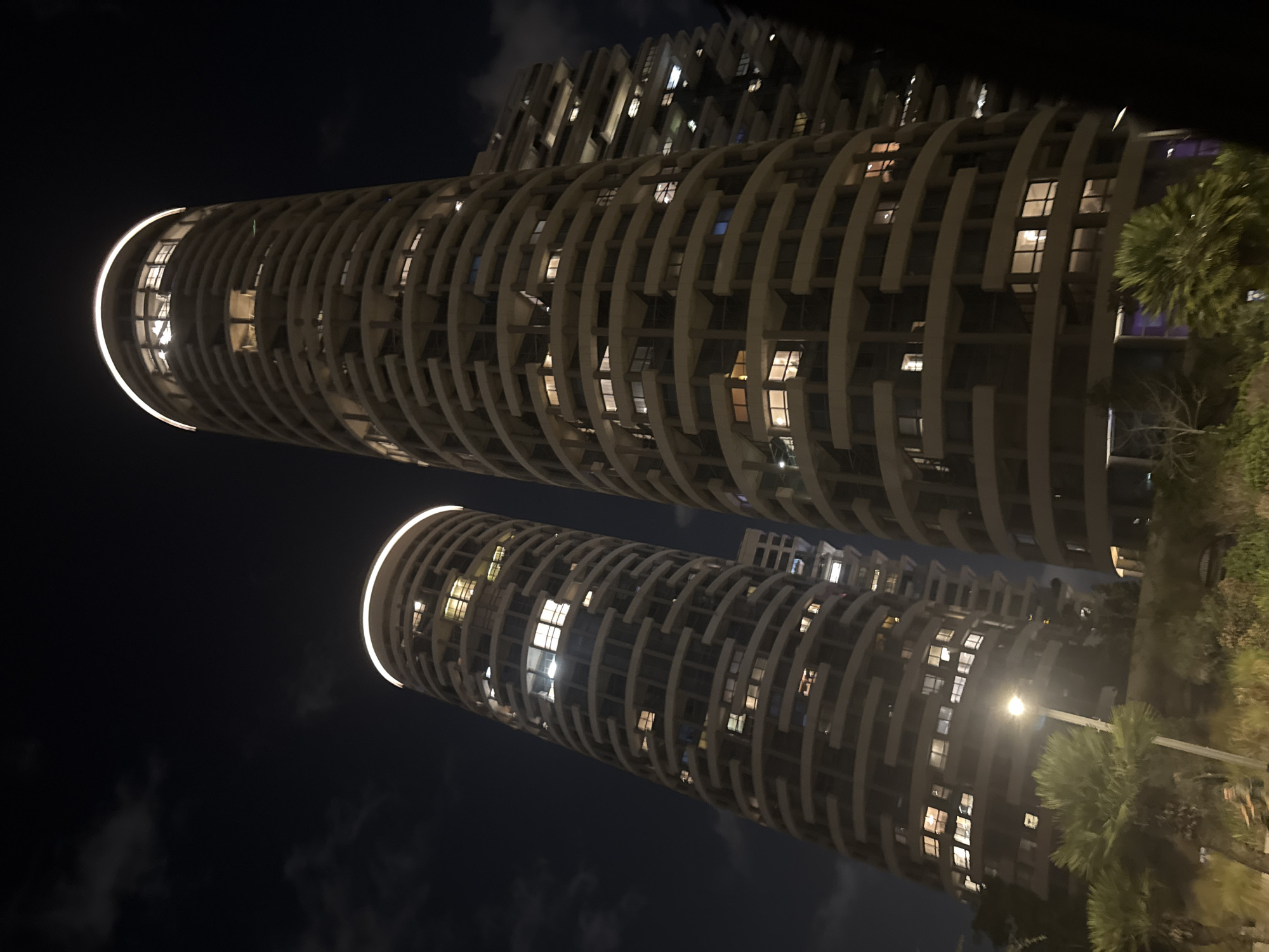 Twin cylindrical towers illuminate the Tel Aviv night skyline.