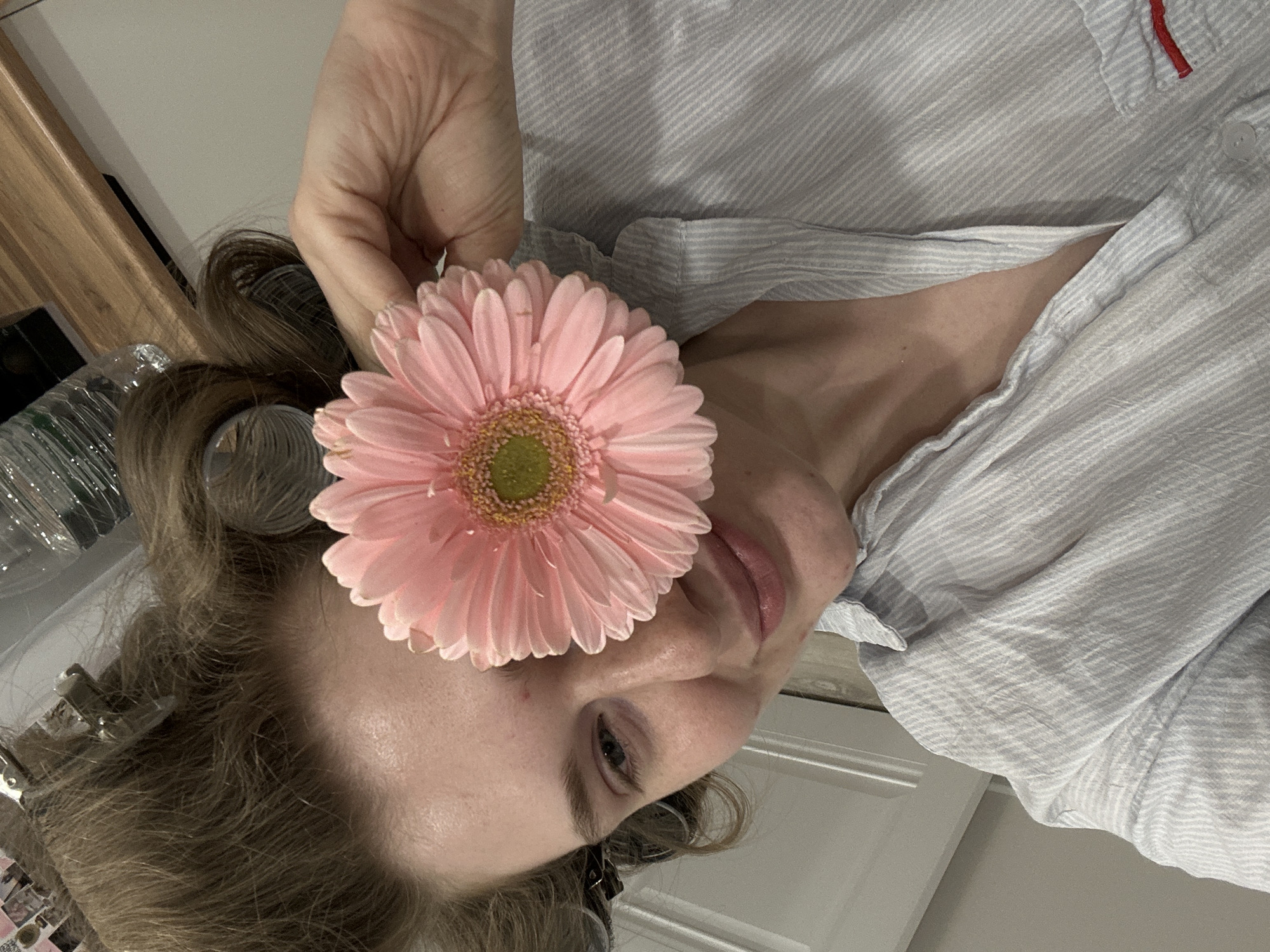 Woman poses with pink flower in Kazan interior