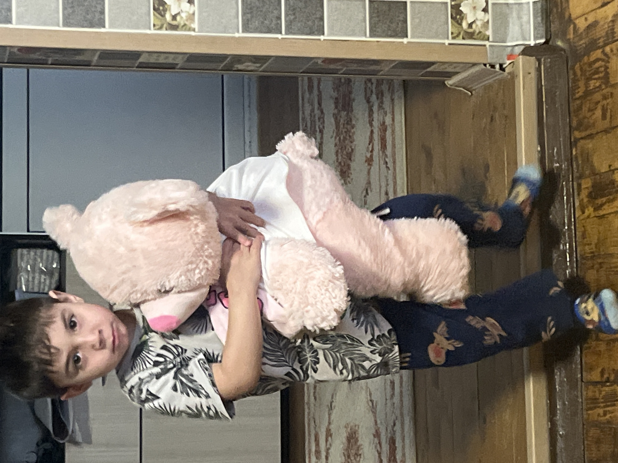 Child with pink teddy bear in decorated room