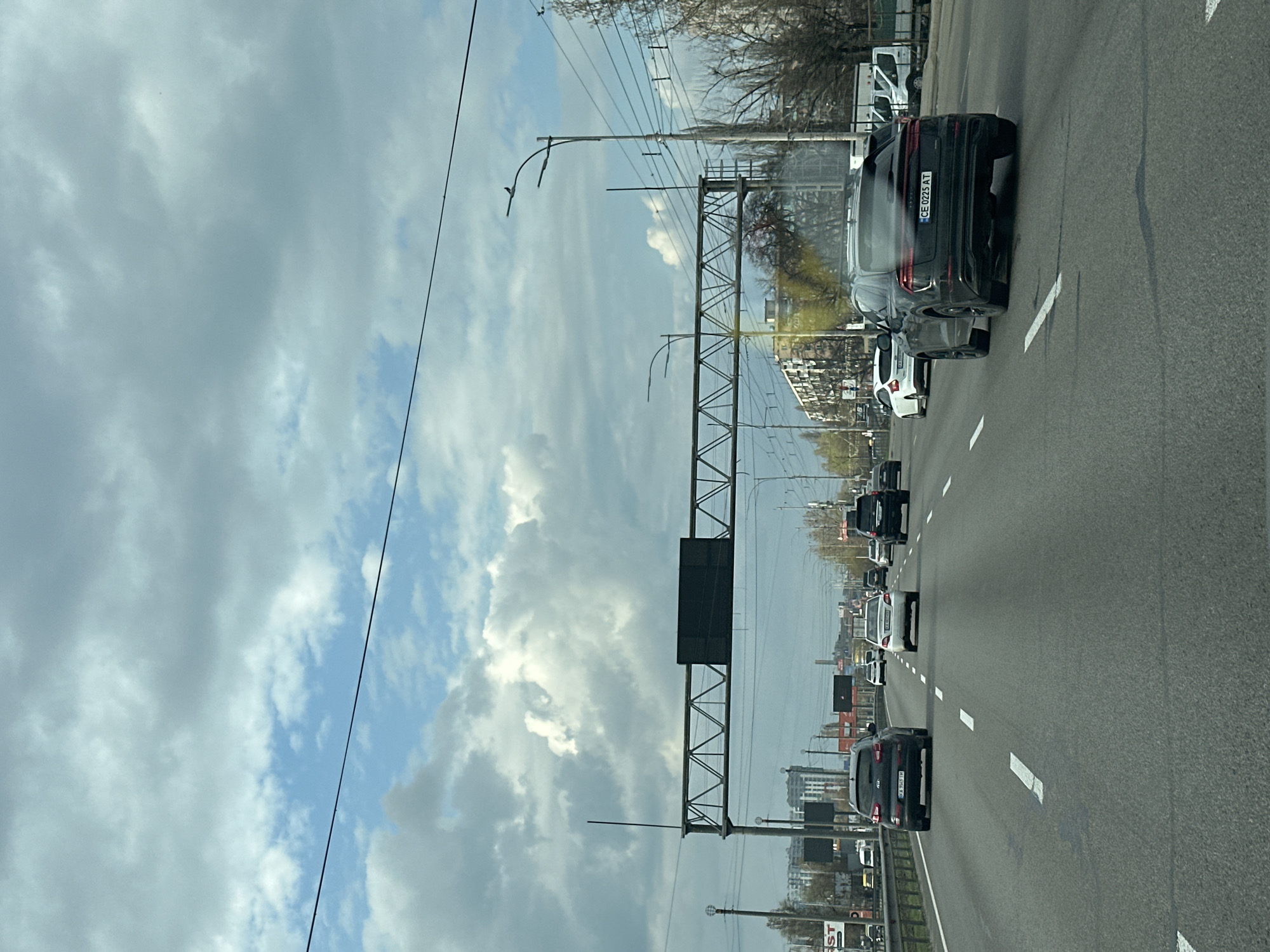 Multi-lane highway traffic observed in Kyiv with overhead infrastructure