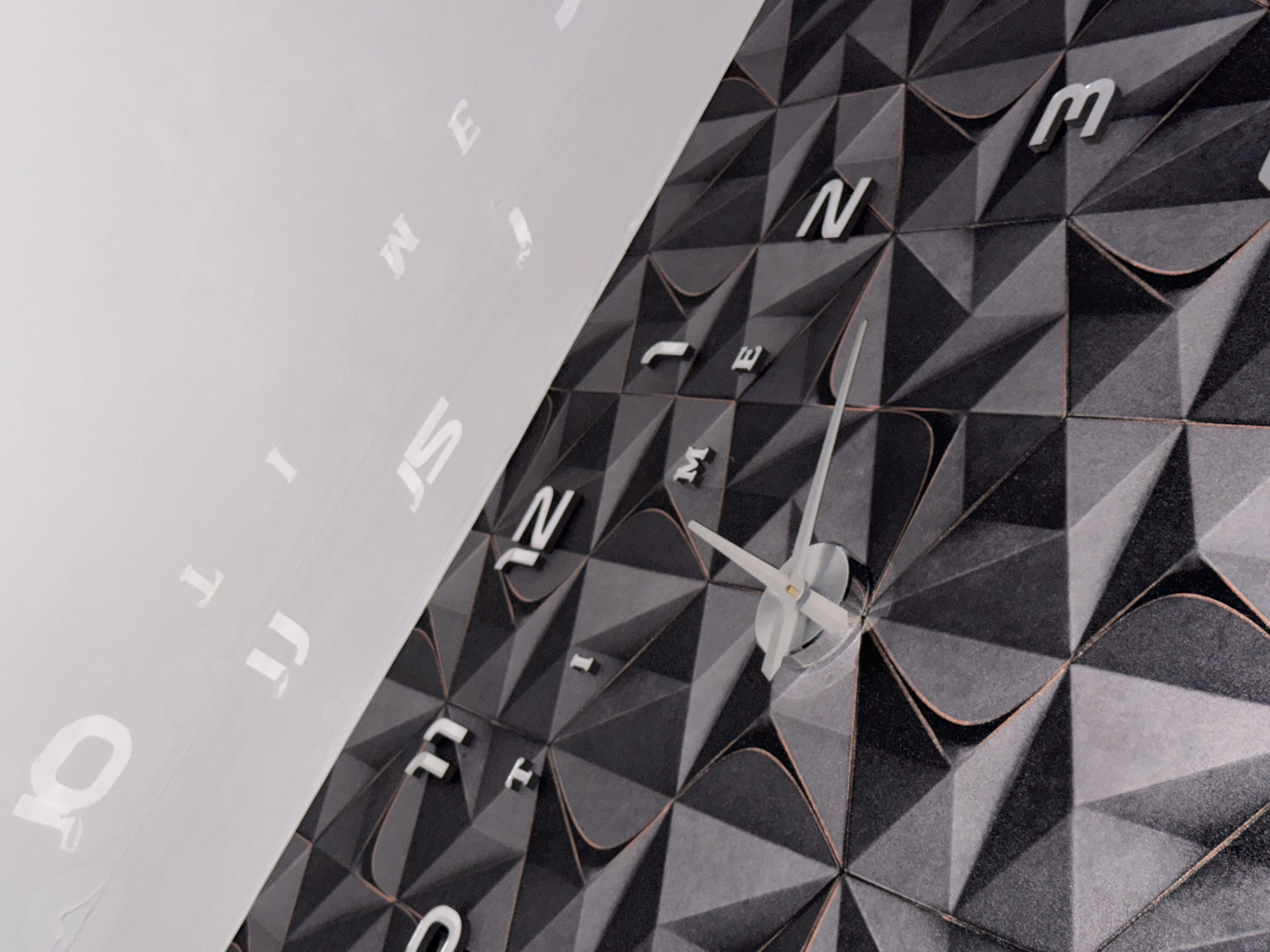 Decorative letter-numeral clock observed on patterned wall in Russia