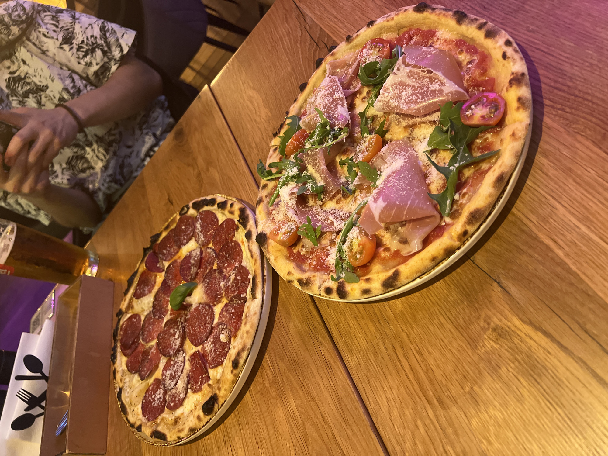 Artisanal pizzas and neon signs at a Krakow restaurant