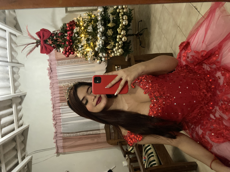 Woman in formal red gown takes mirror selfies in Venezuela