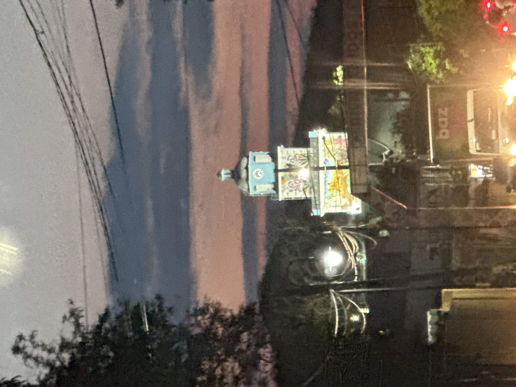 Evening traffic flows past decorated tower in Xochitepec