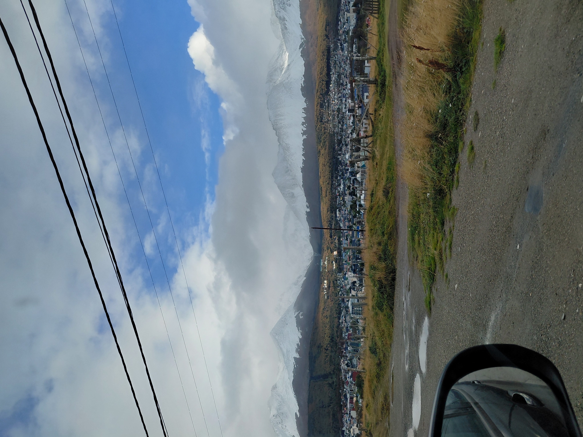 Vehicle travels damp unpaved road in Ushuaia outskirts