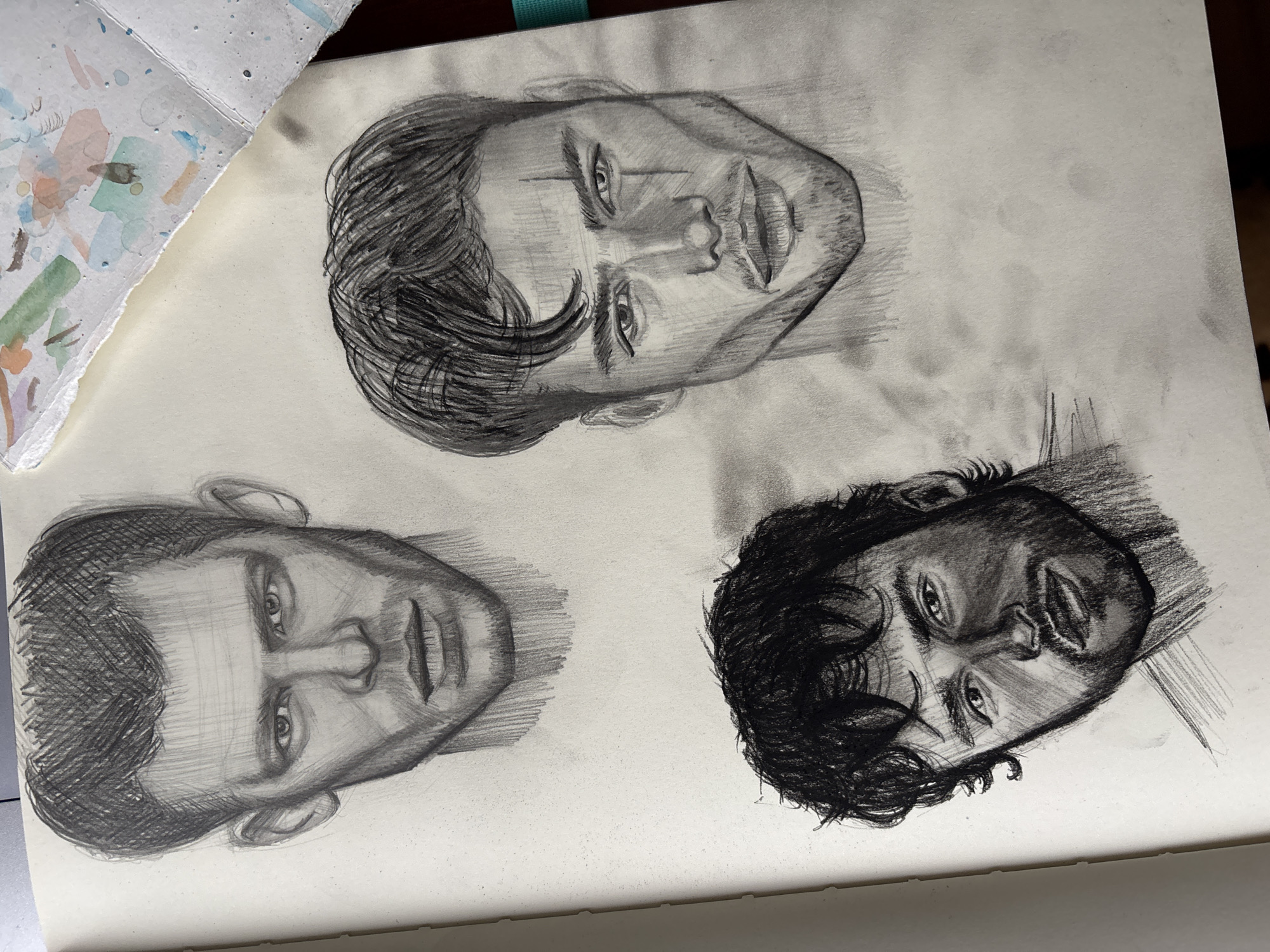 Artist sketches male portraits in Izhevsk sketchbook