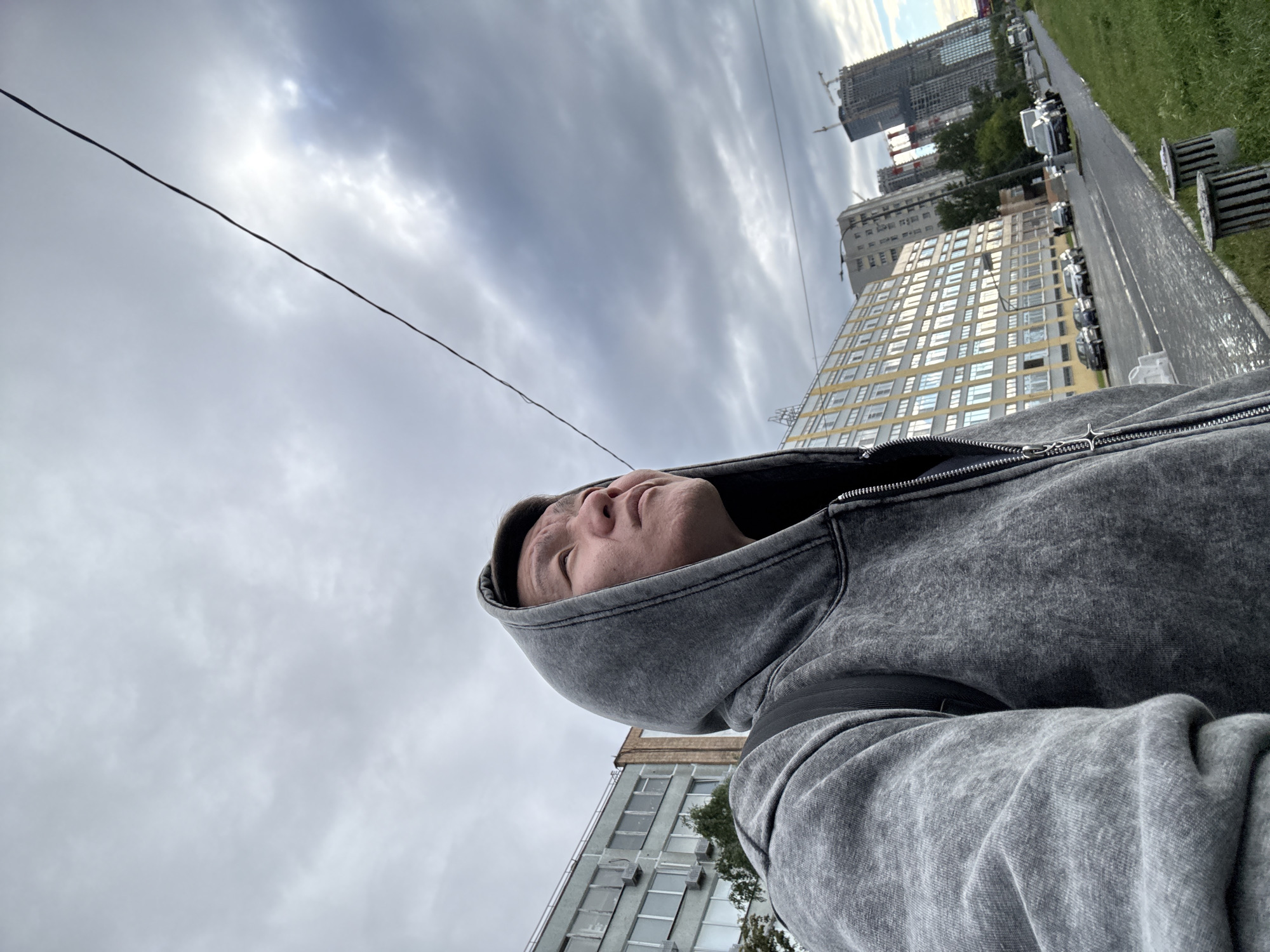 Low-angle street portrait in Dolgoprudny, grey hoodie in frame