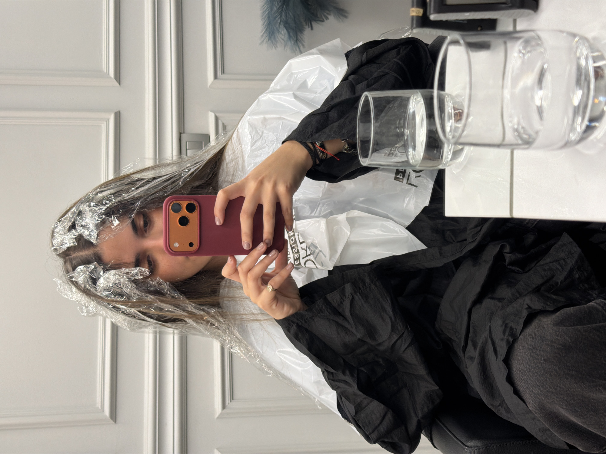 Woman takes mirror selfie during hair treatment in Milan
