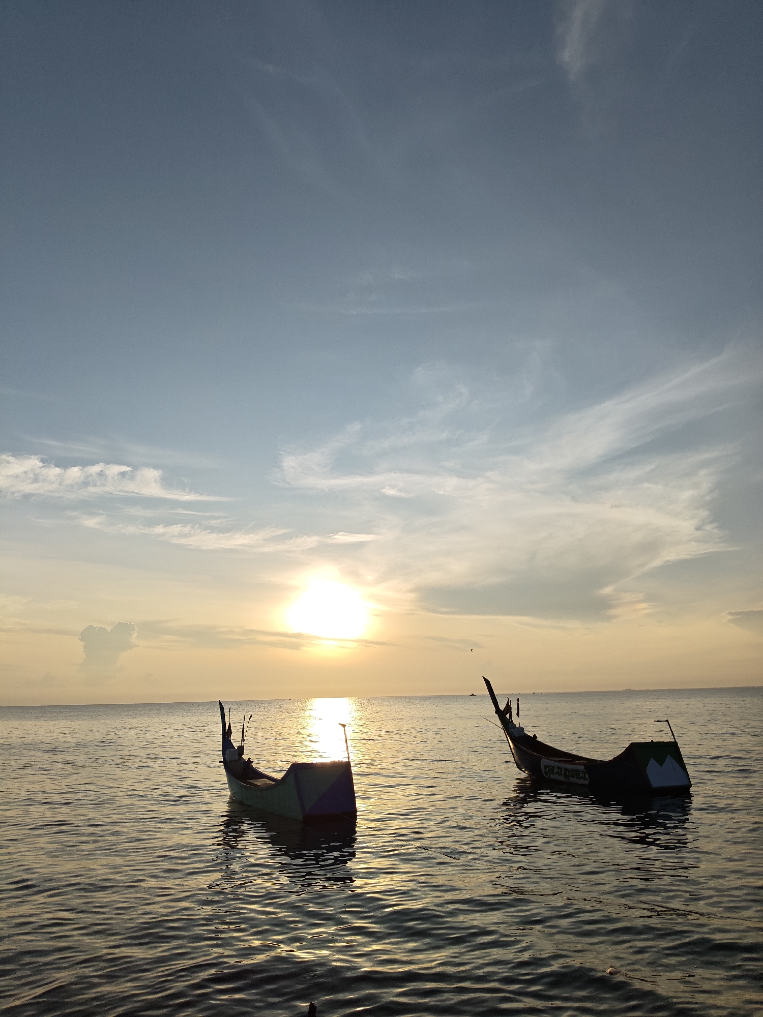 Fishing boats spotted in calm sunset waters off Lhokseumawe