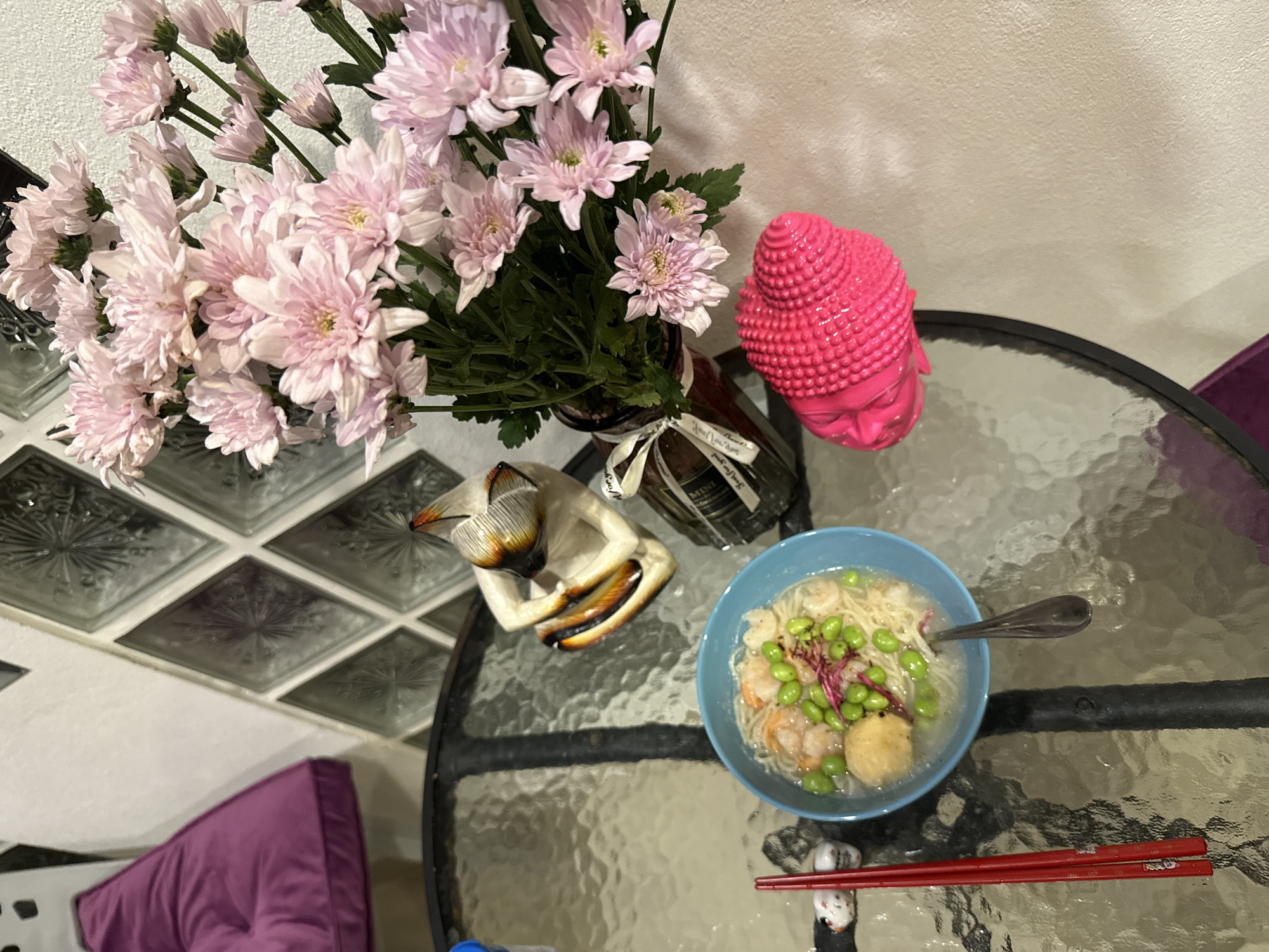Pink flowers and Buddha statue arranged on Ko Samui table