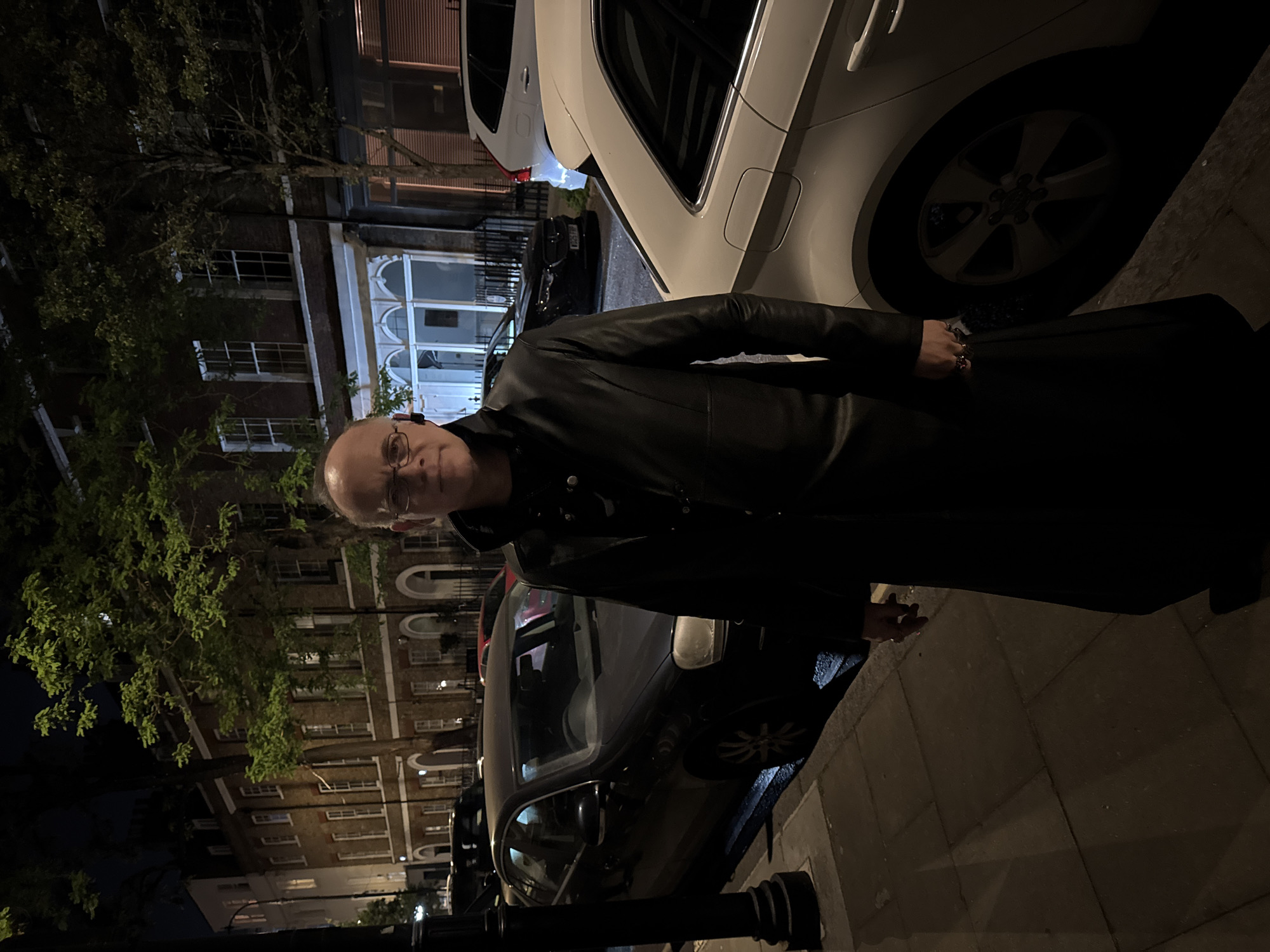 Man in glasses observed standing on London sidewalk at night
