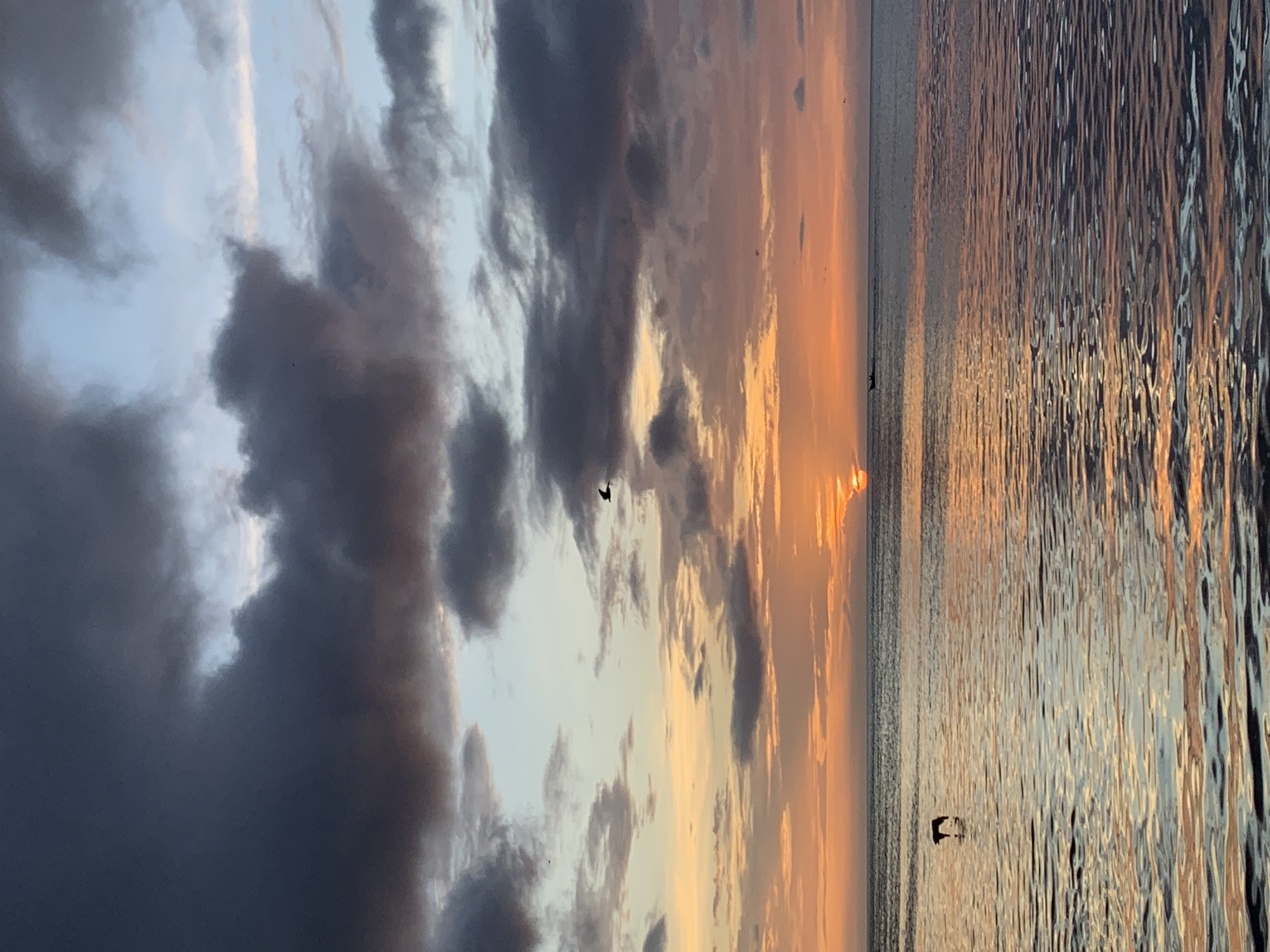 Sunset over Juan Griego bay, fishing boats and stormy skies