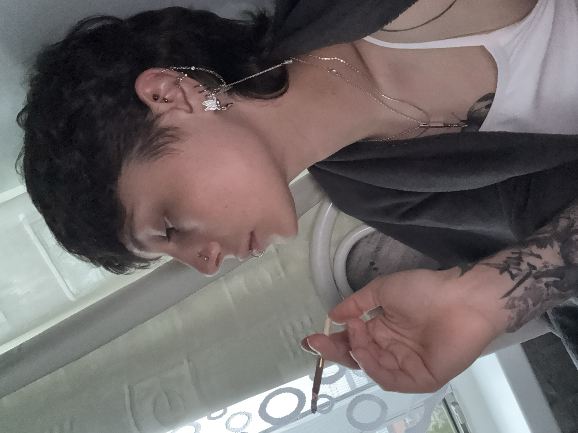 Pierced individual with mullet spotted smoking indoors in Saint Petersburg