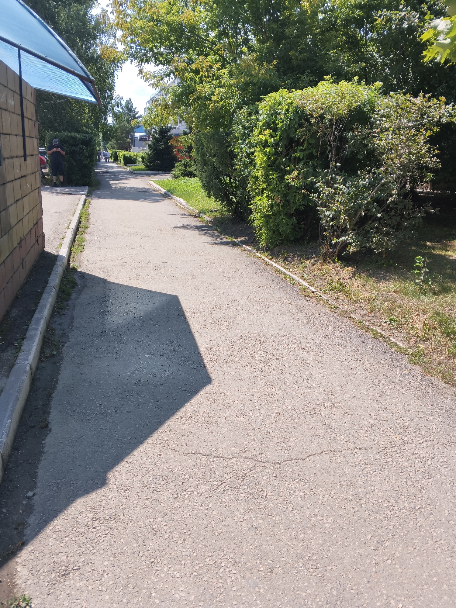 Sunny sidewalk and Soviet-era streetscape in Shchuchinsk, Kazakhstan