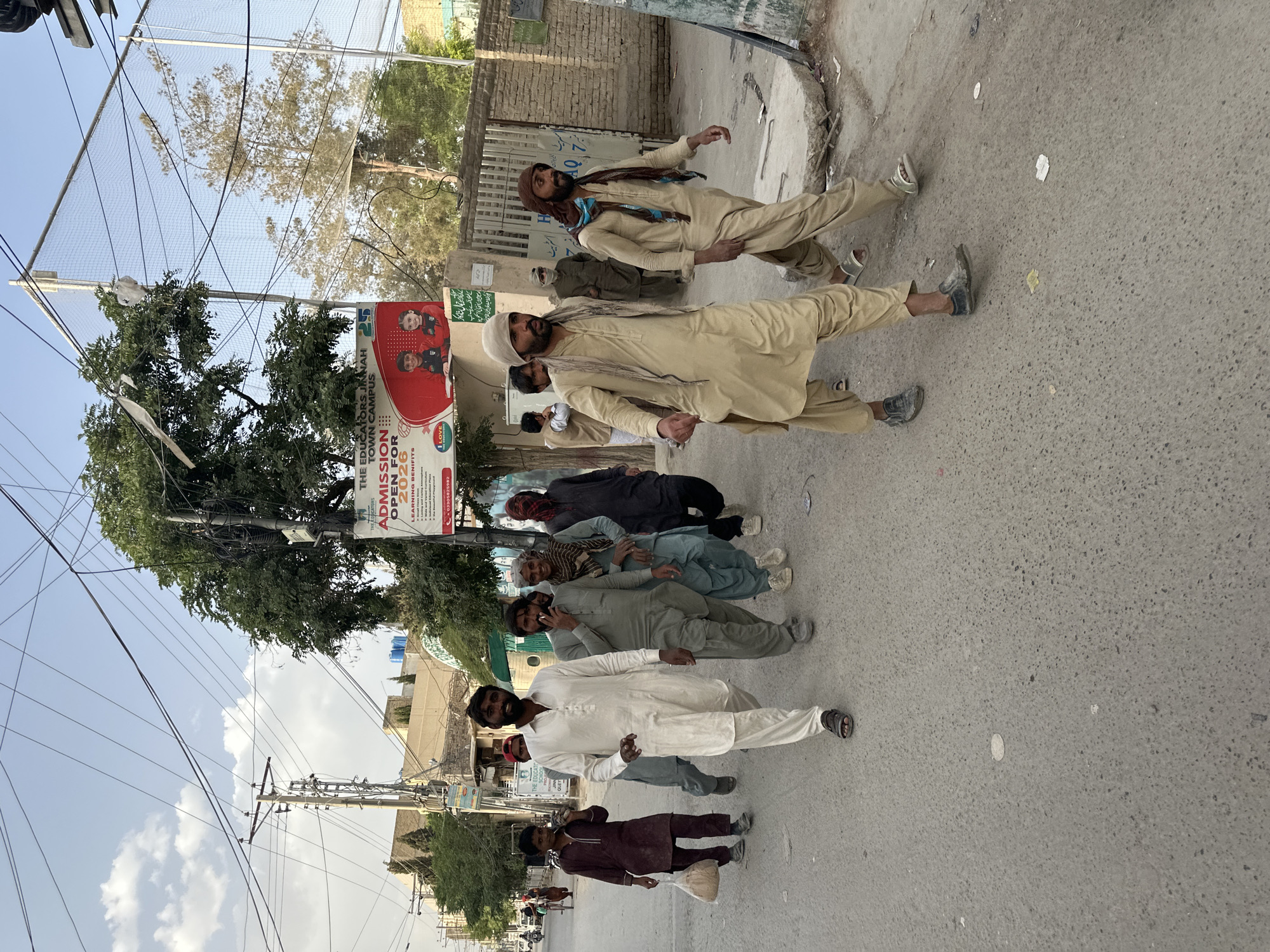 Seven men in traditional dress line street in Quetta