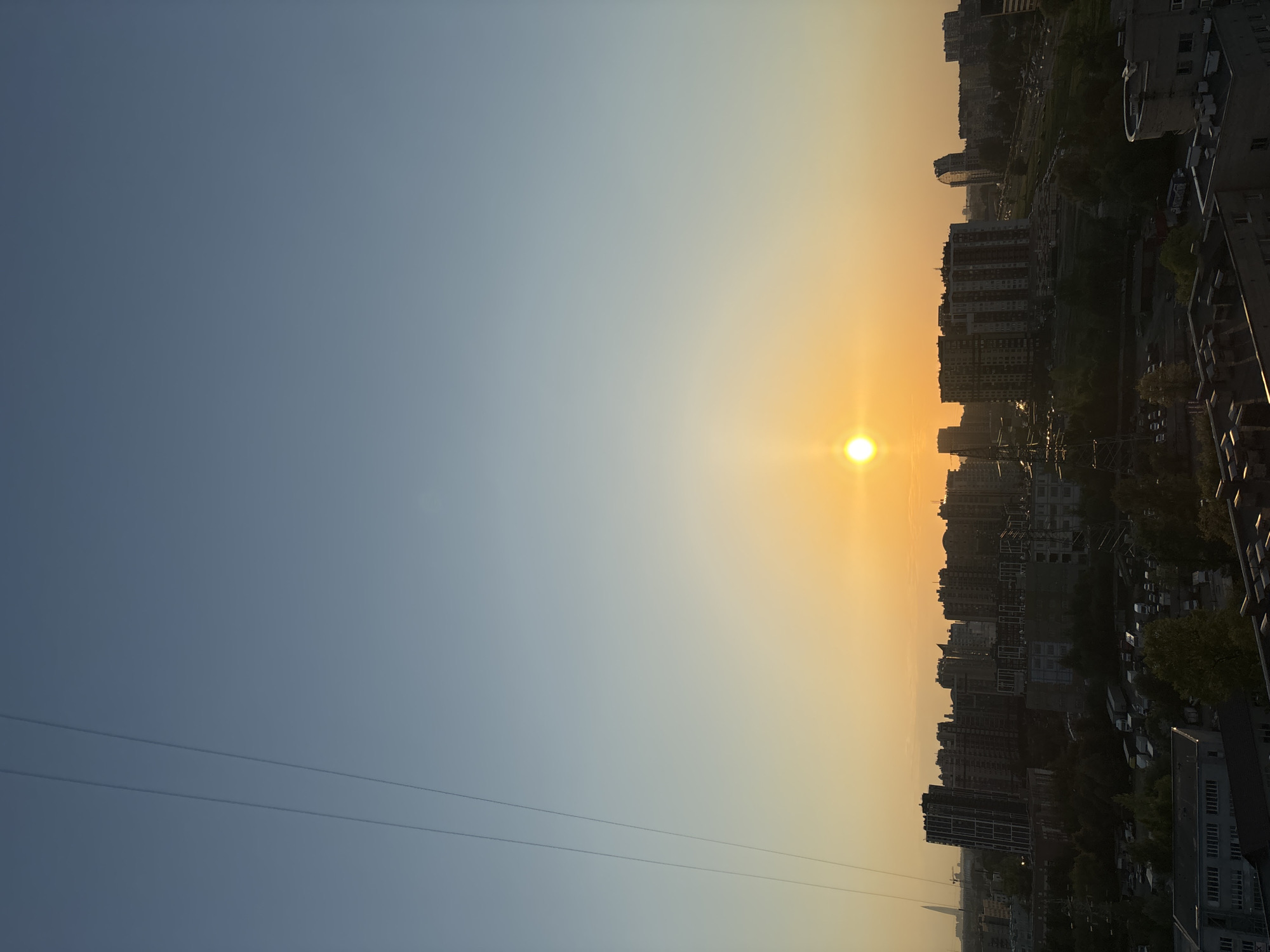 Witness captures sunset over dense urban cityscape