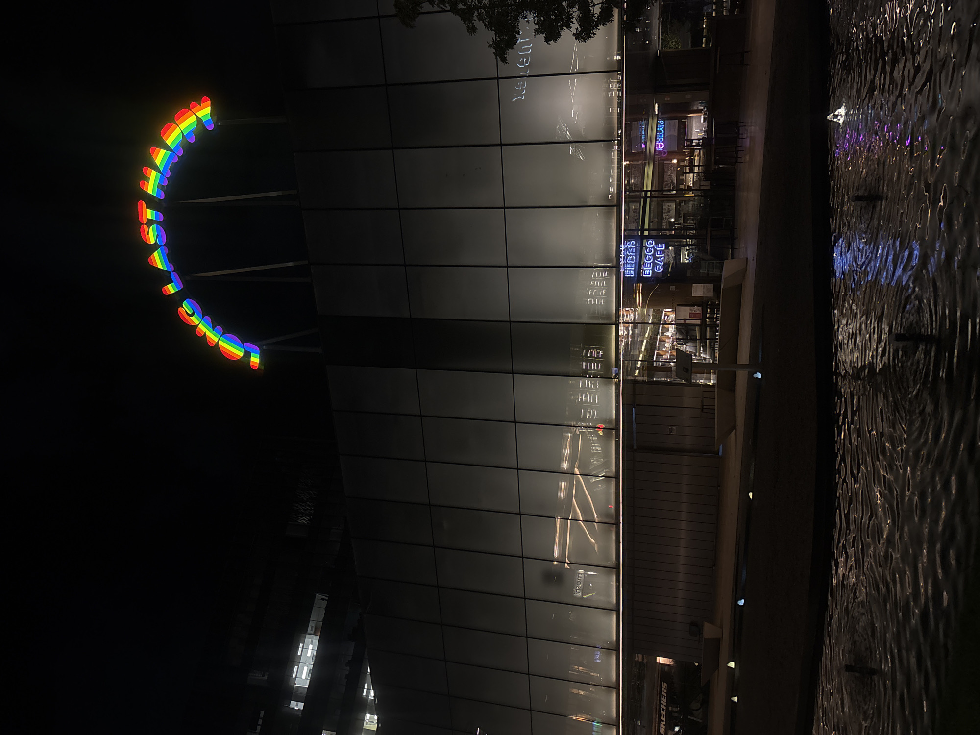 Rainbow 'LOVE WINS' sign illuminated at urban building