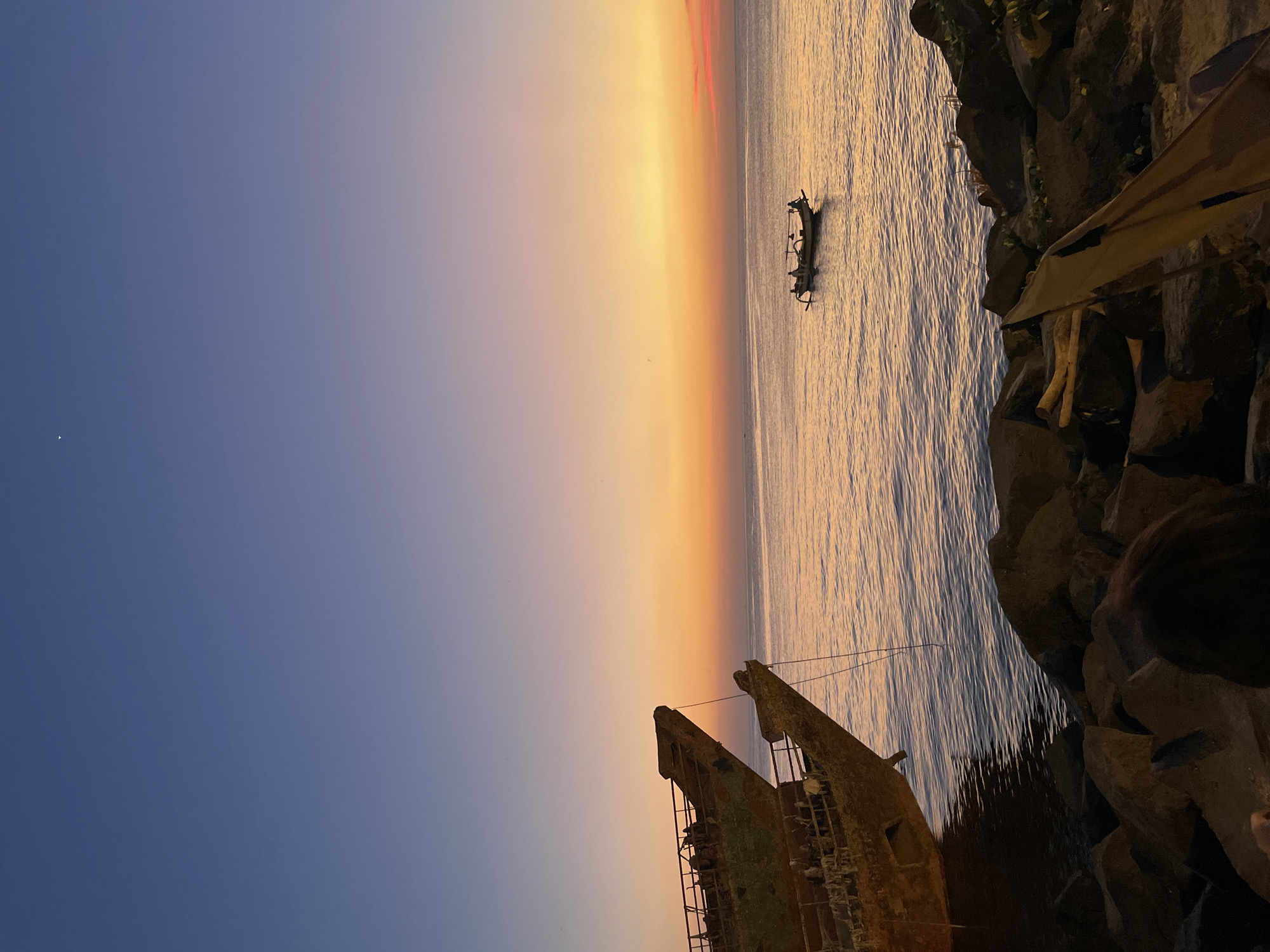 Sunset drinks at a Manado beach bar with a shipwreck view
