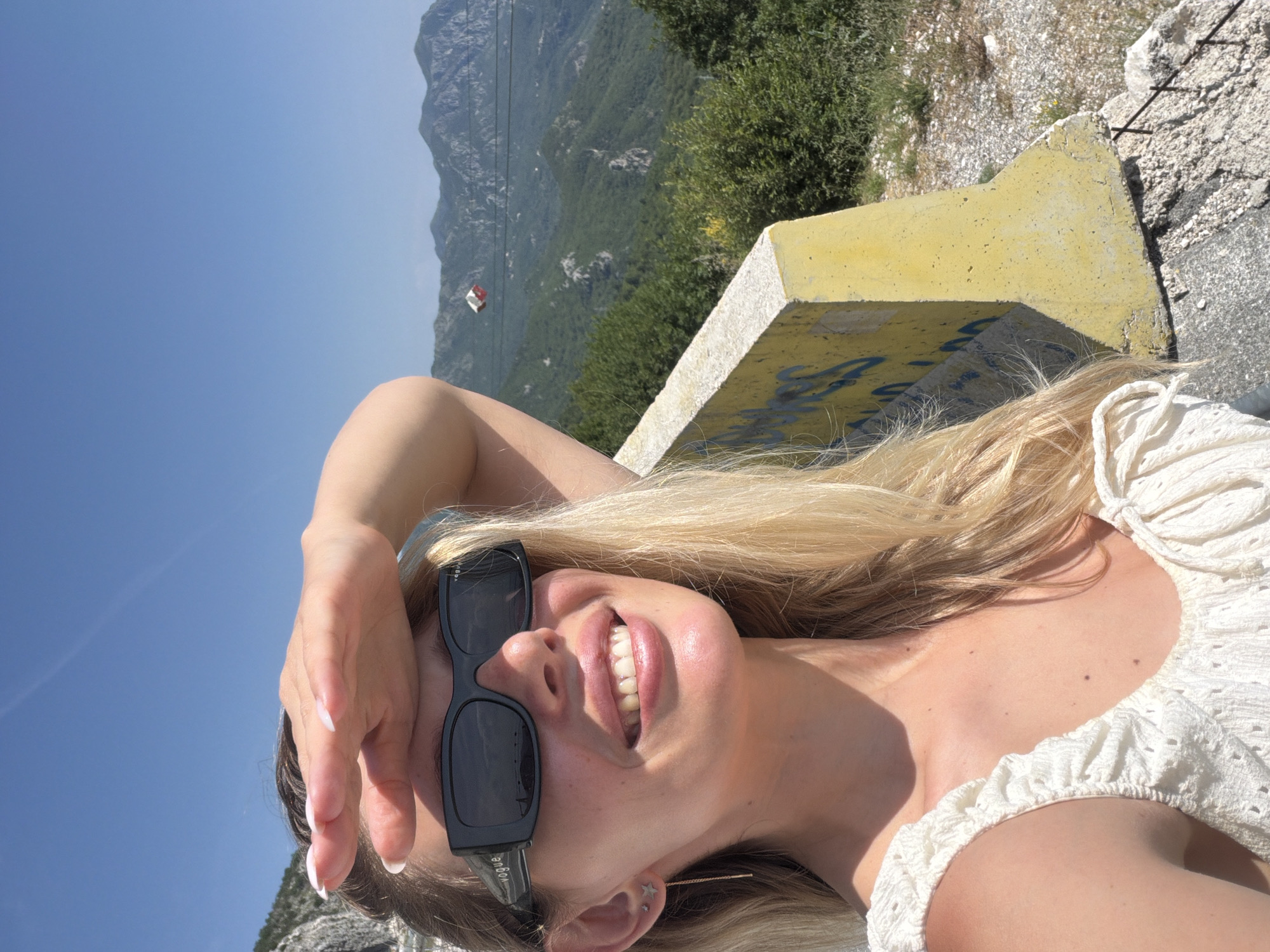 Woman poses for photos at Montenegro coastal overlook