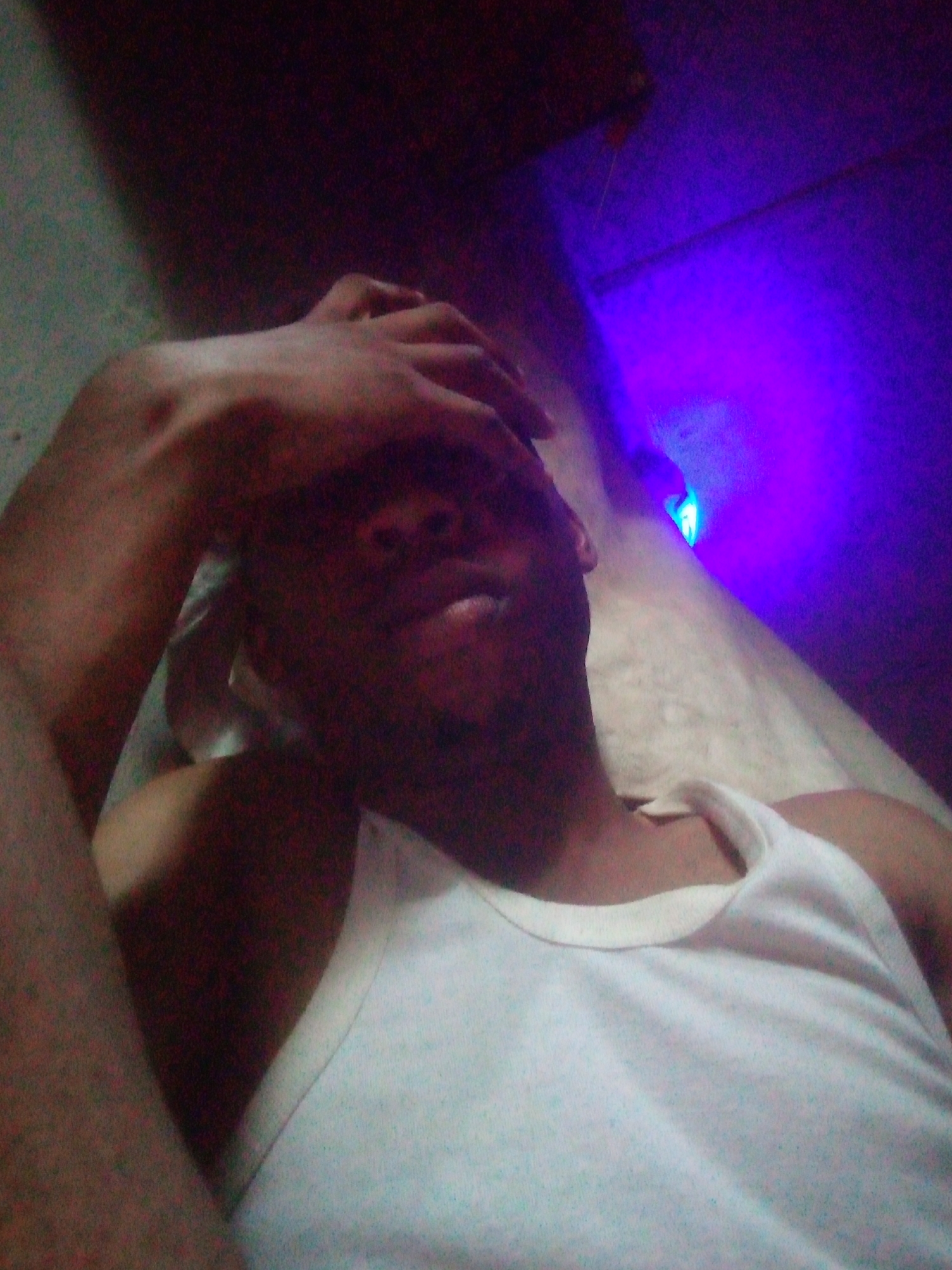 Person rests, drinks in dimly lit room
