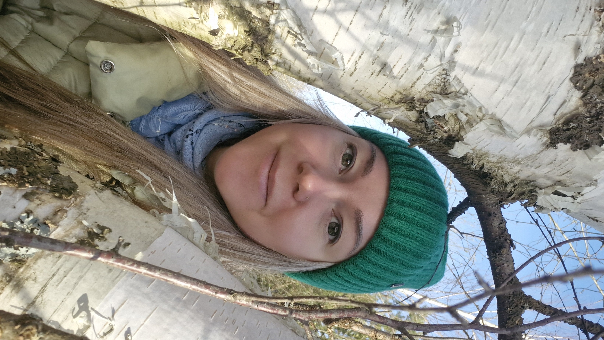 Woman rests under birch tree in rural Russia