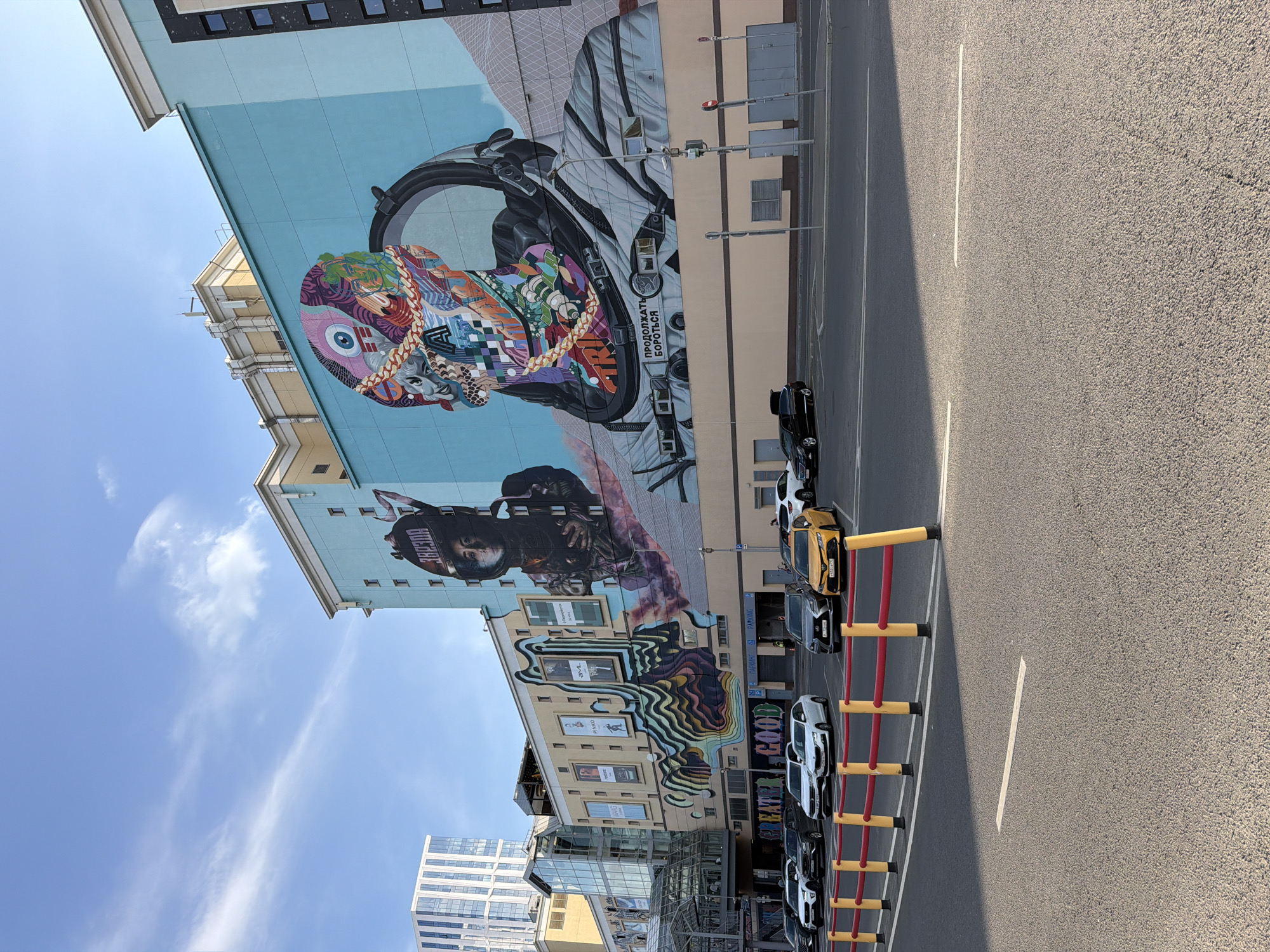 Street murals, metro escalators, and city movement on a July afternoon