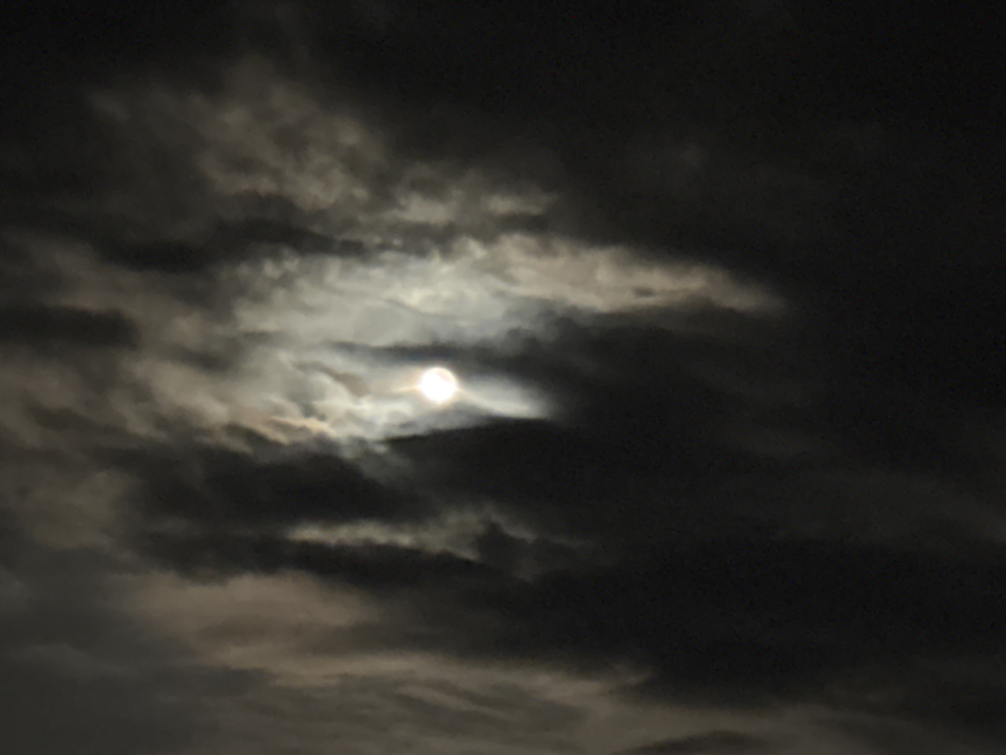 Bright moon observed through heavy clouds in Chaikovsky, Russia