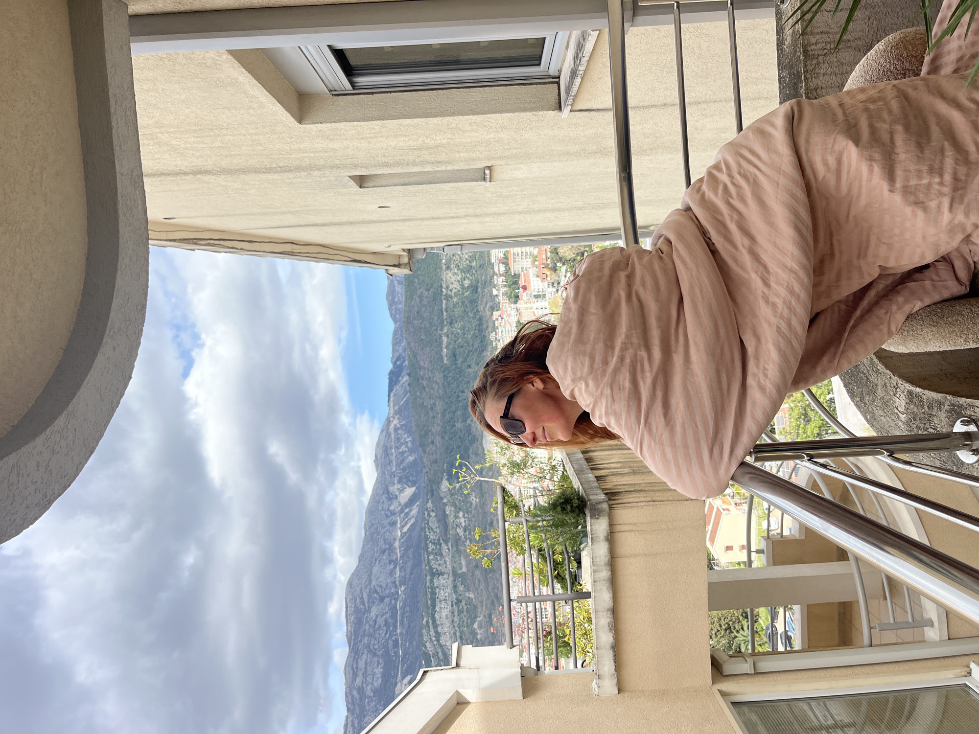 Woman enjoys balcony meal in Budva, Montenegro