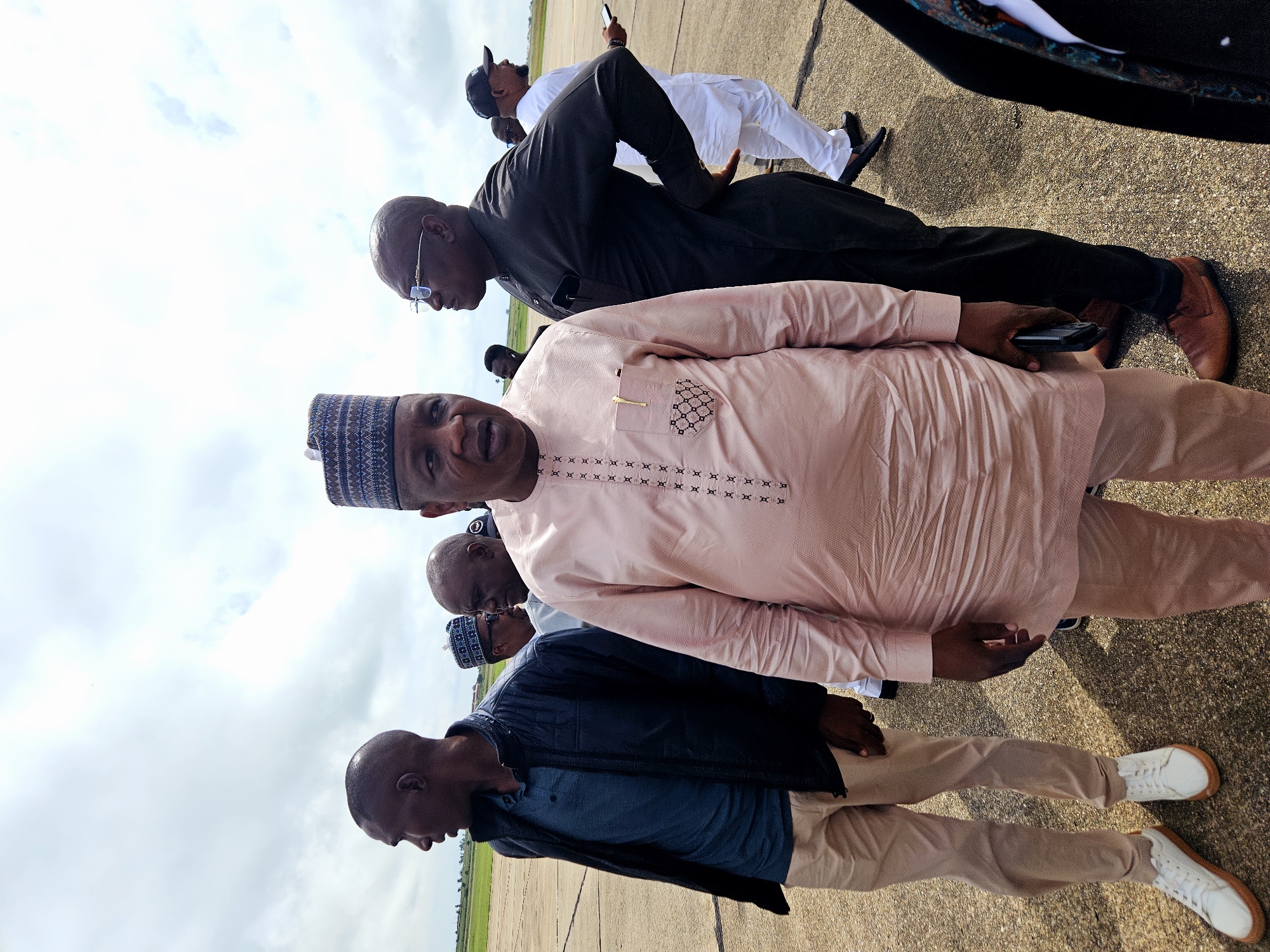 Group in traditional dress gathered around a private jet on tarmac