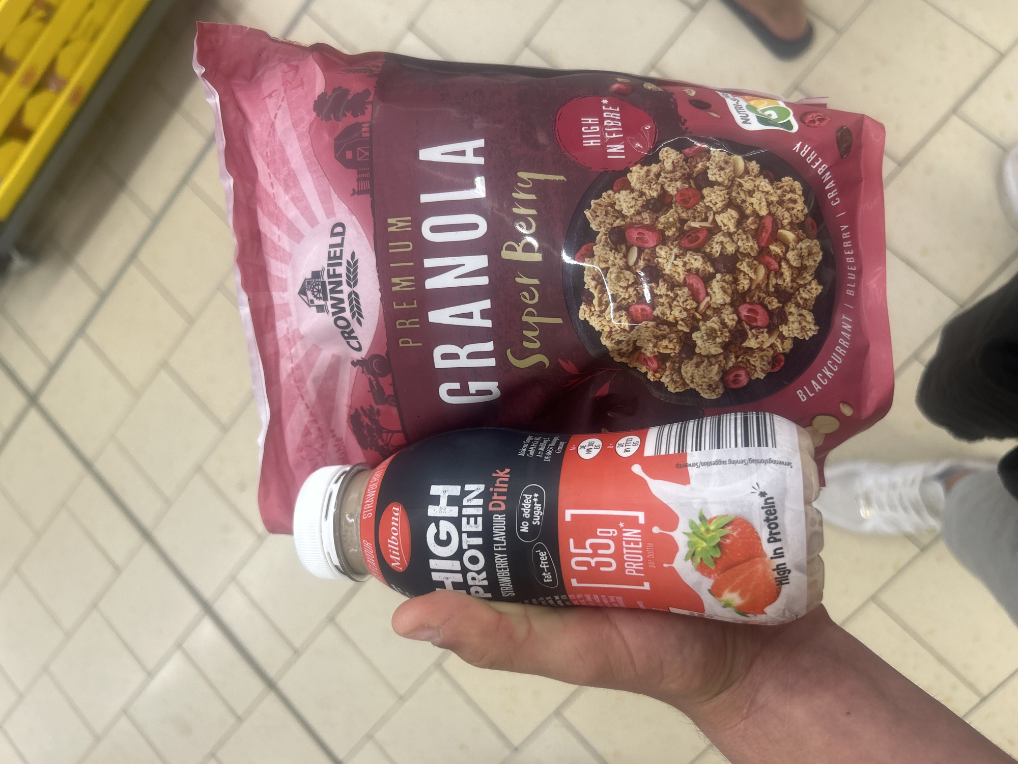 Shopper holds granola and protein drink in Ede store
