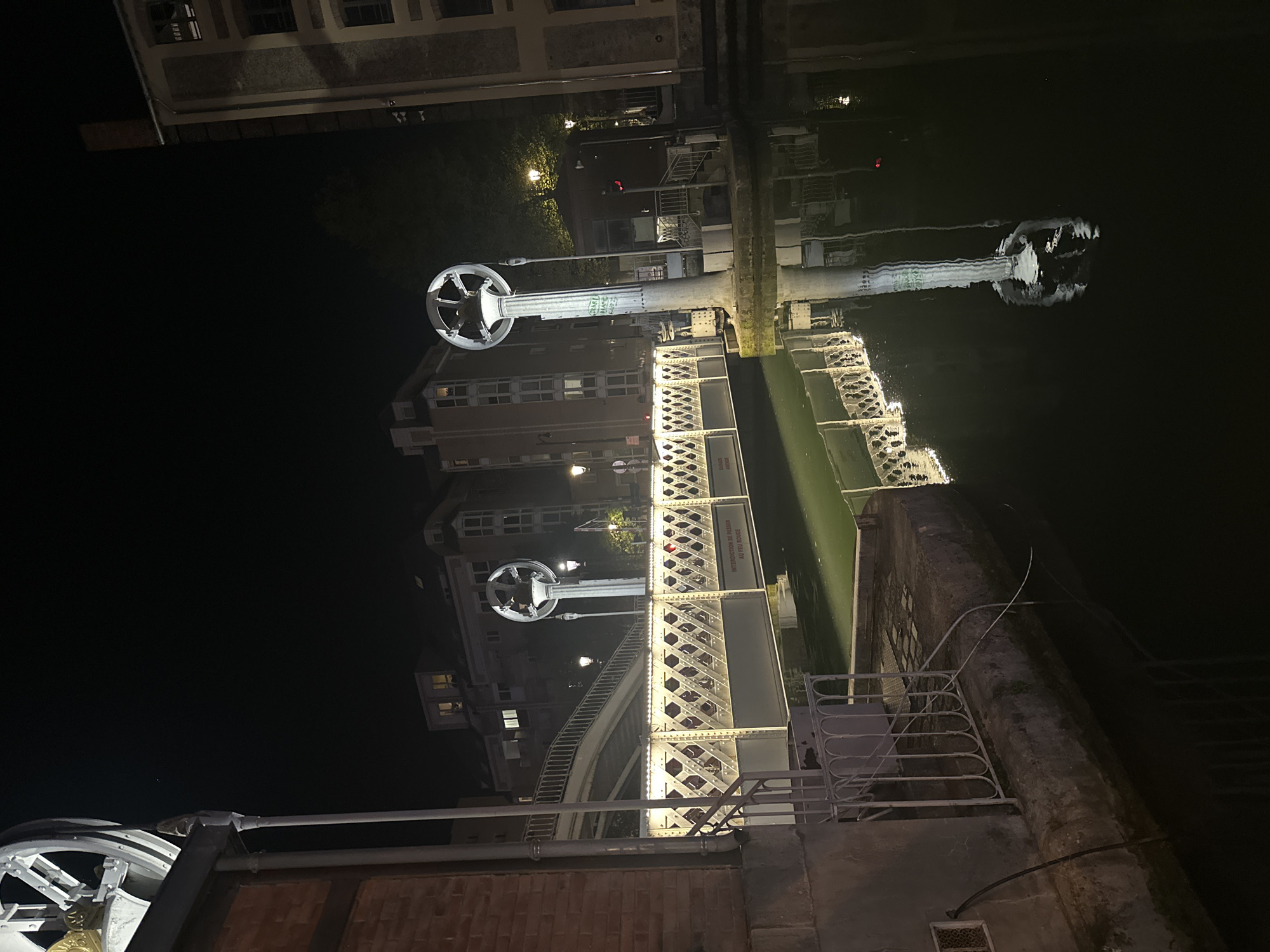 Nighttime view of illuminated Passerelle Simone-de-Beauvoir bridge in Paris