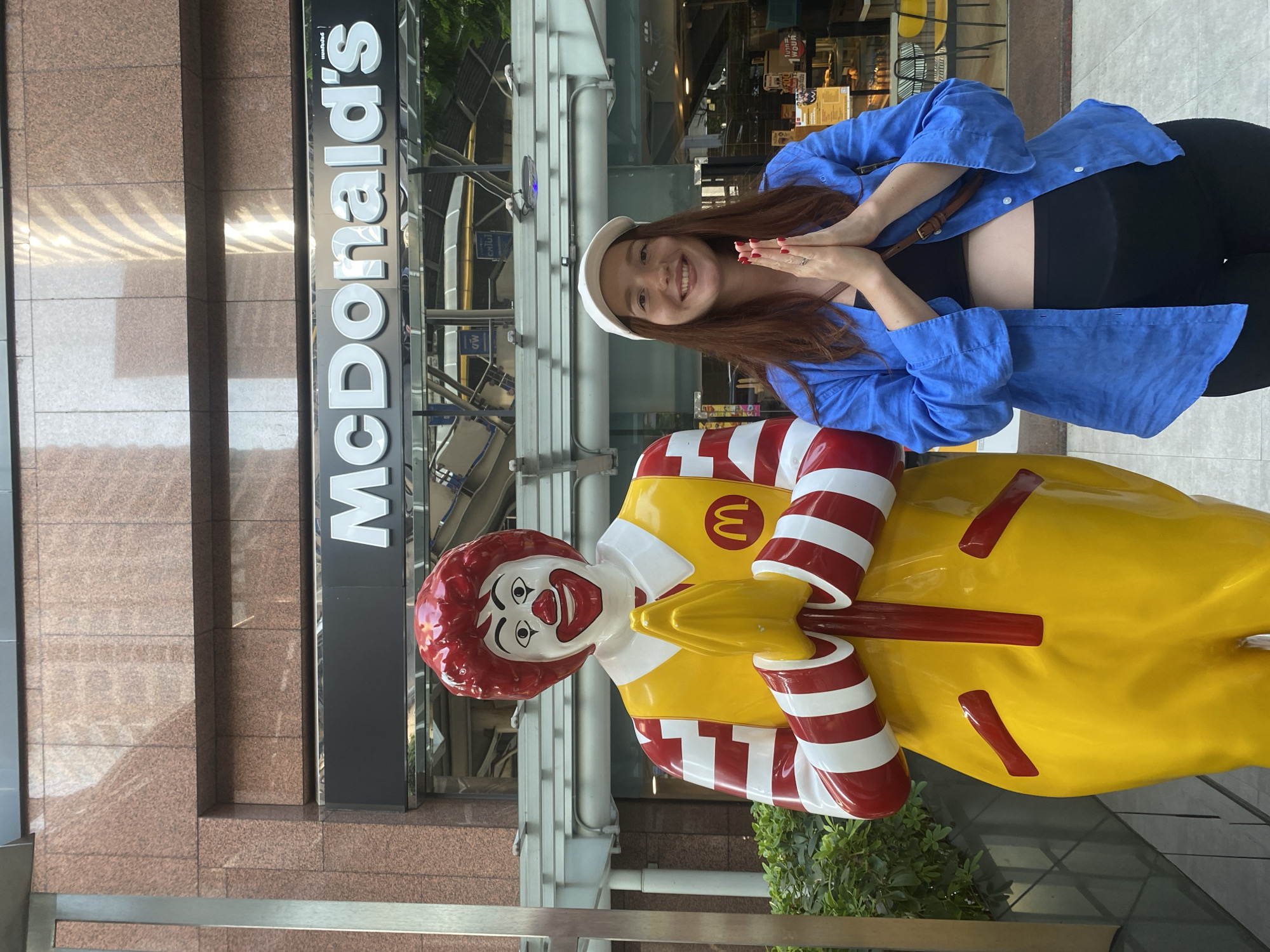 Tourist poses with Ronald McDonald statue in Bangkok