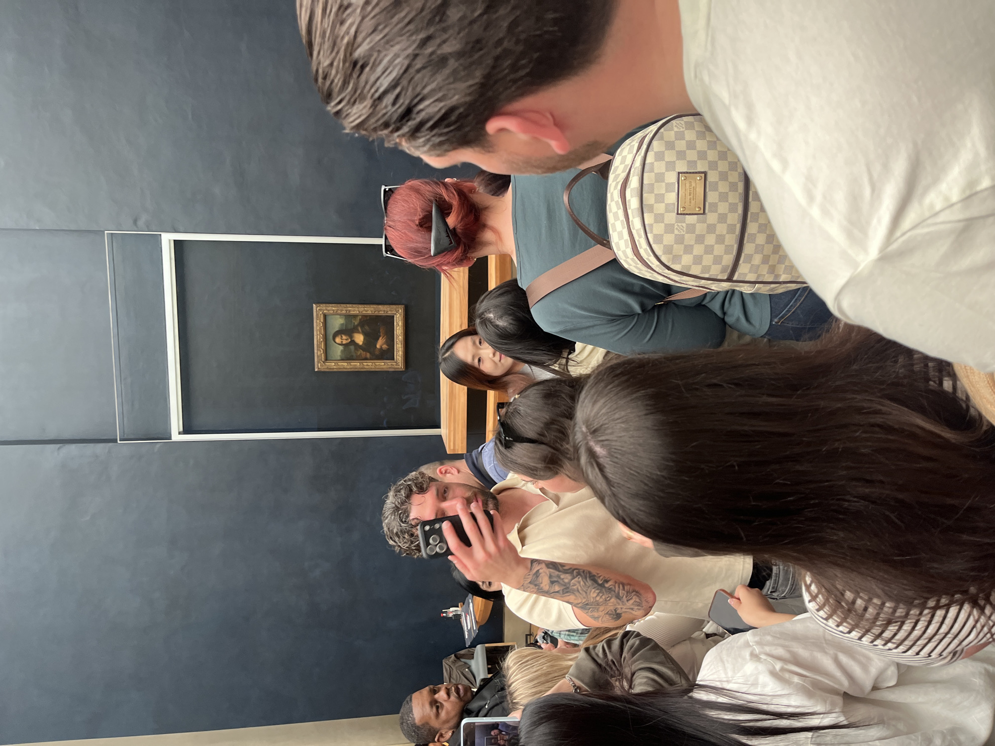 Tourists view Mona Lisa at Louvre during midday visit