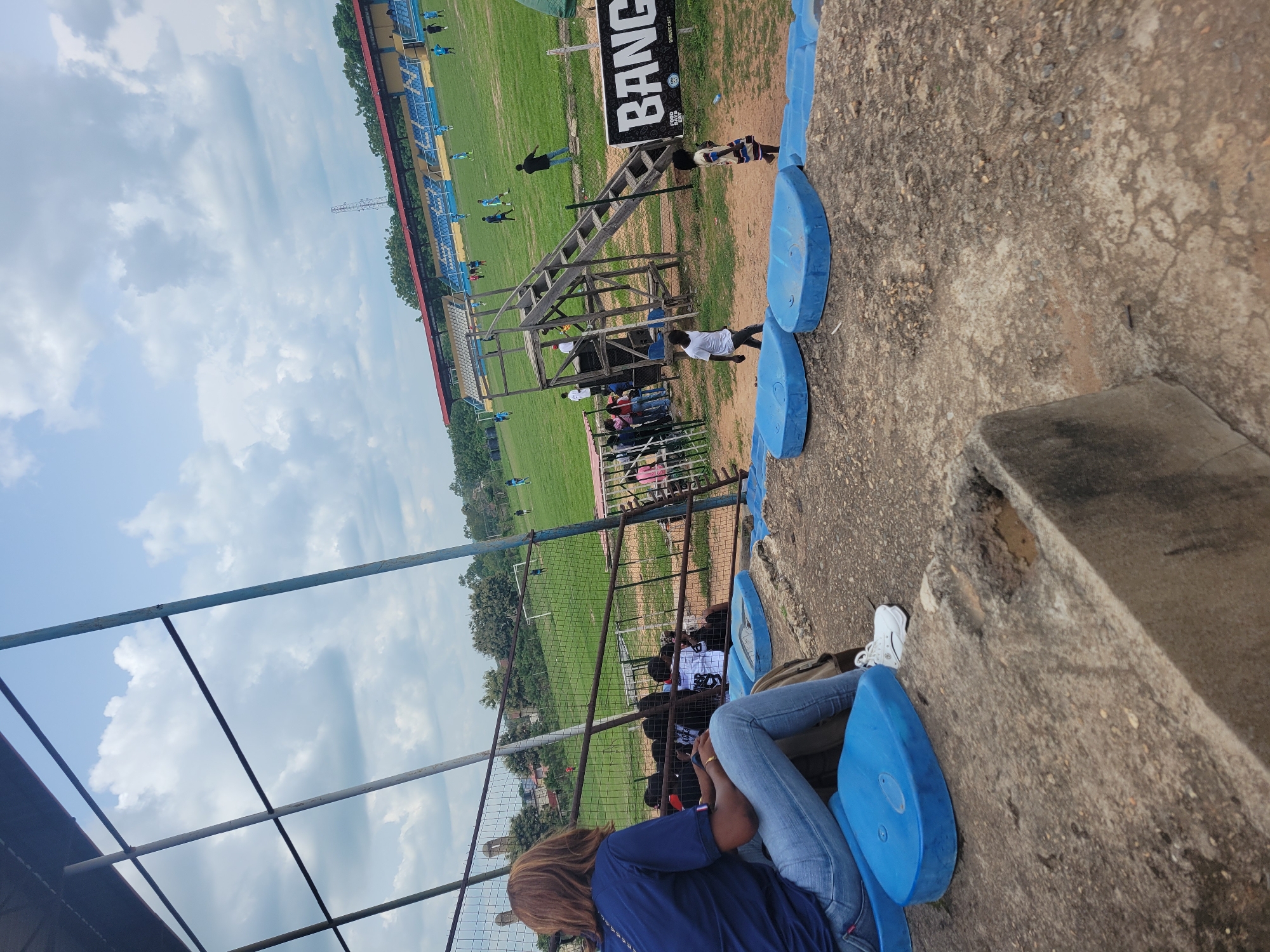 Soccer match draws spectators to outdoor stadium with blue seating