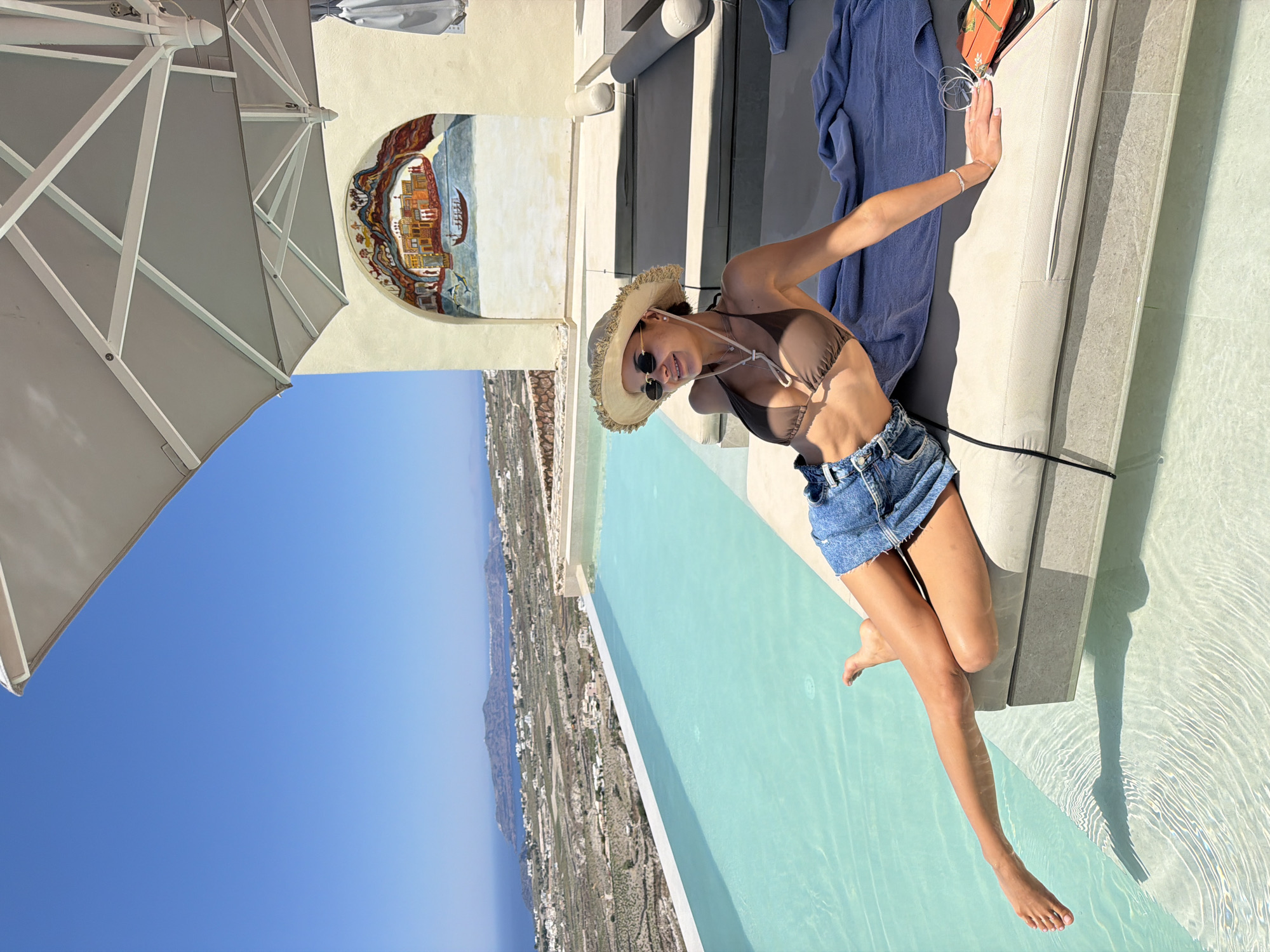 Caldera views and designer hats: a Santorini pool morning