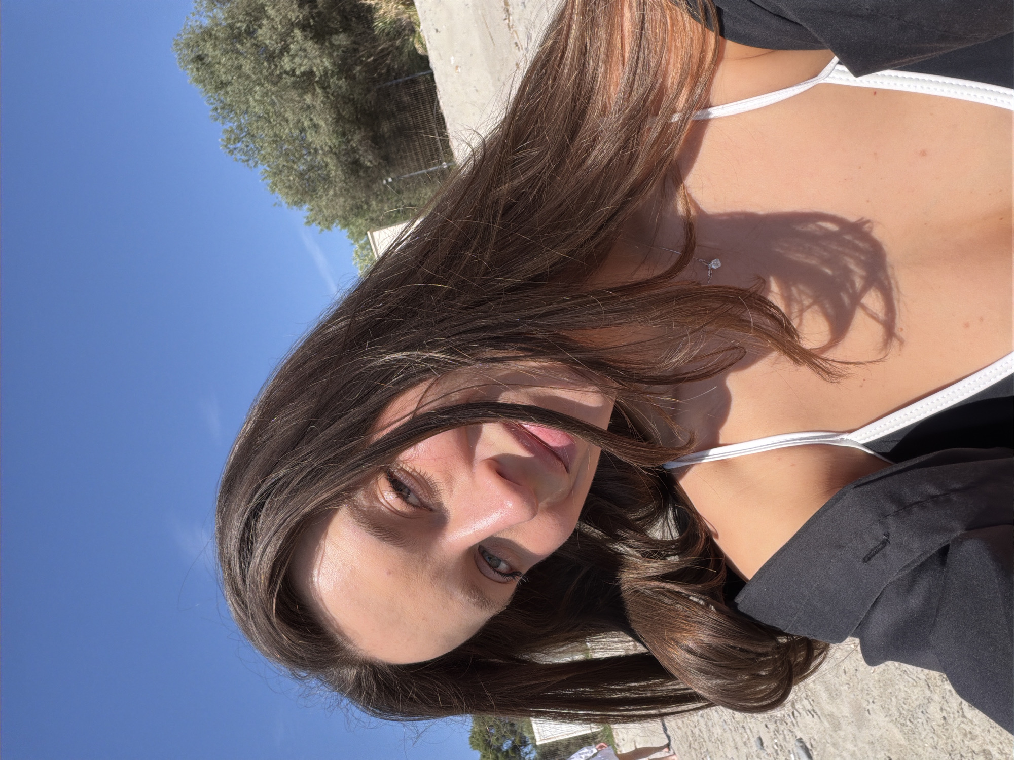 Woman takes selfie under clear skies in Milovići, Montenegro