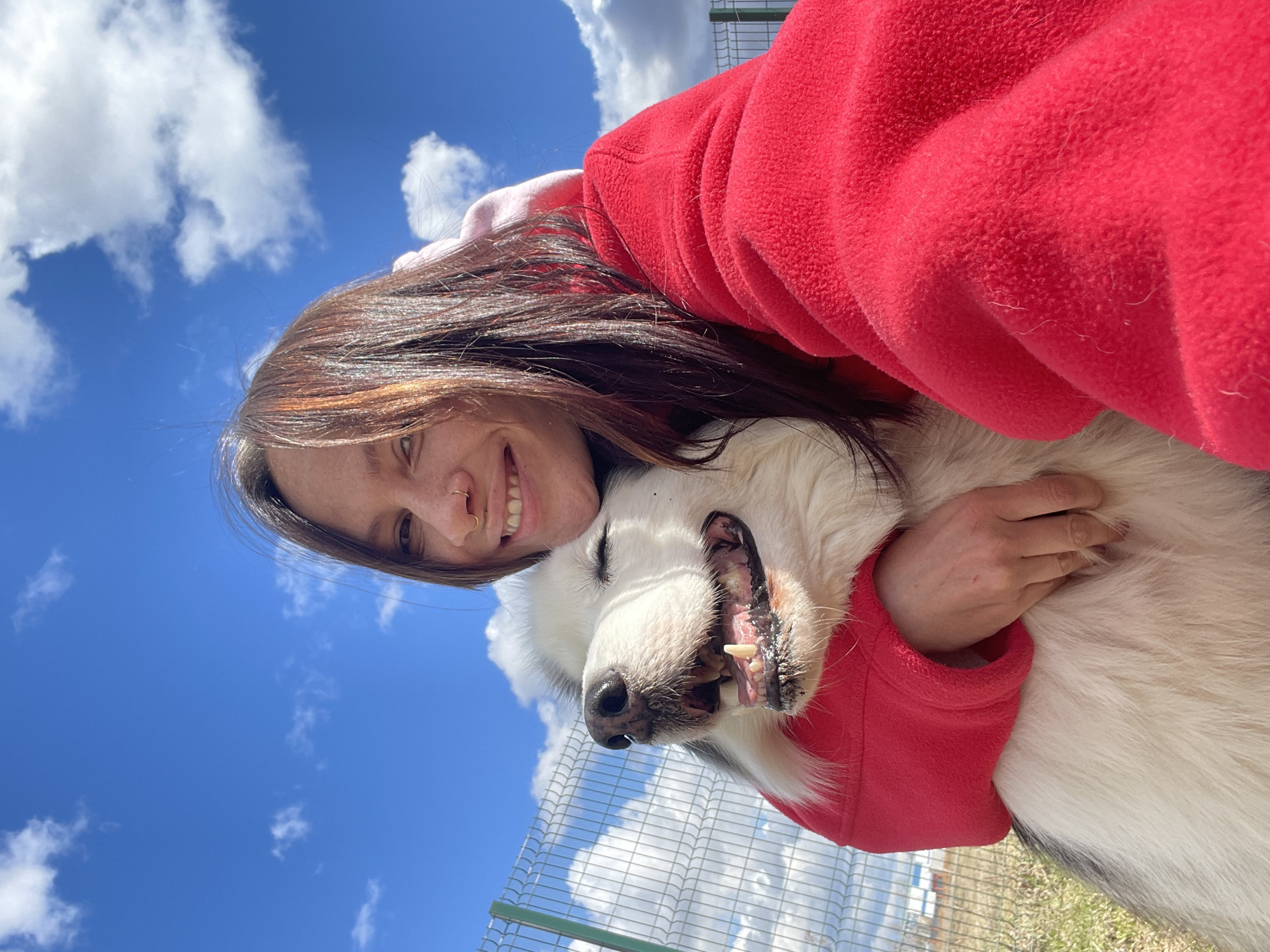Woman embraces white dog in outdoor scene, Sokol Russia