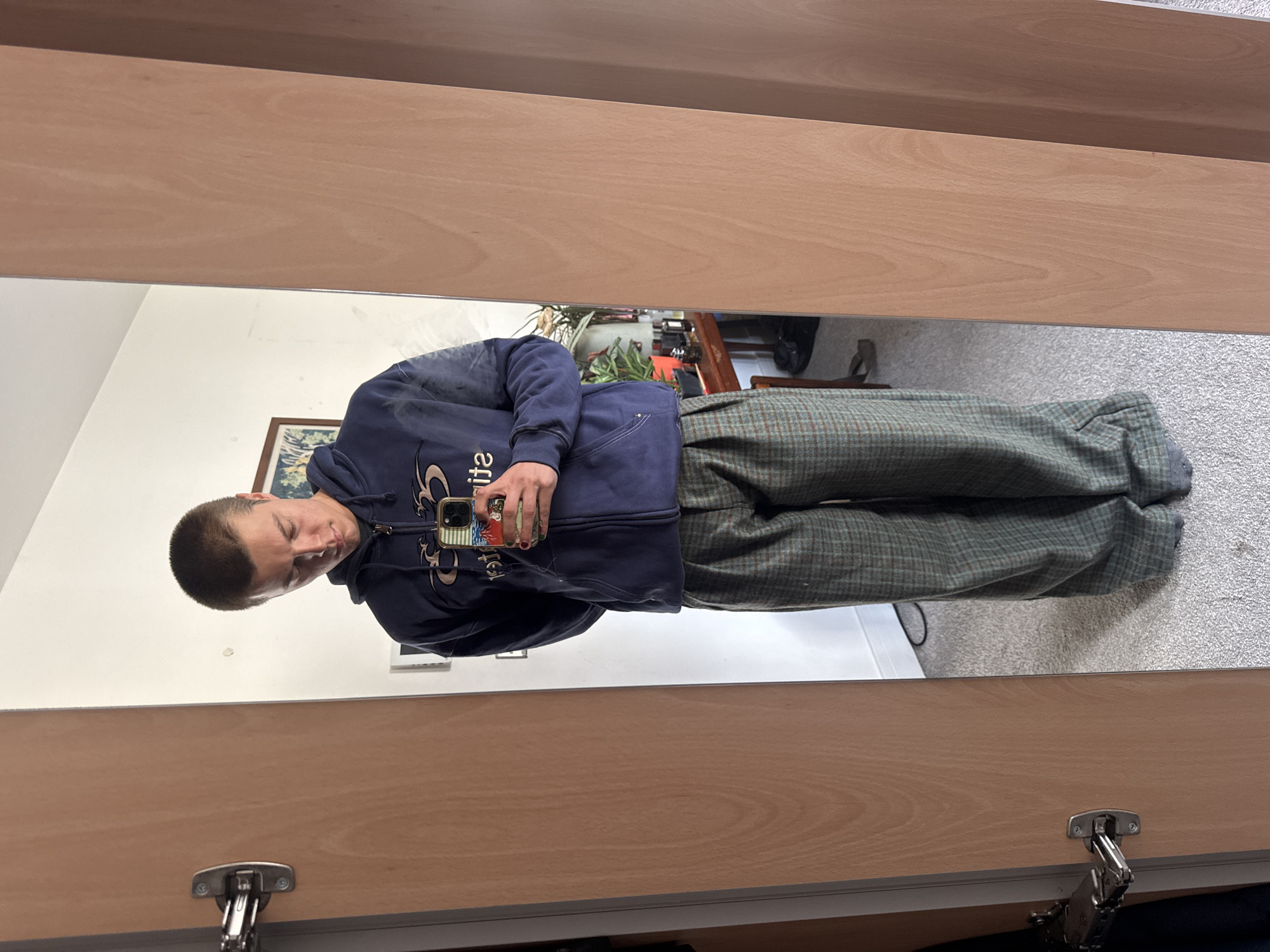 Person checks phone in mirror, central London morning