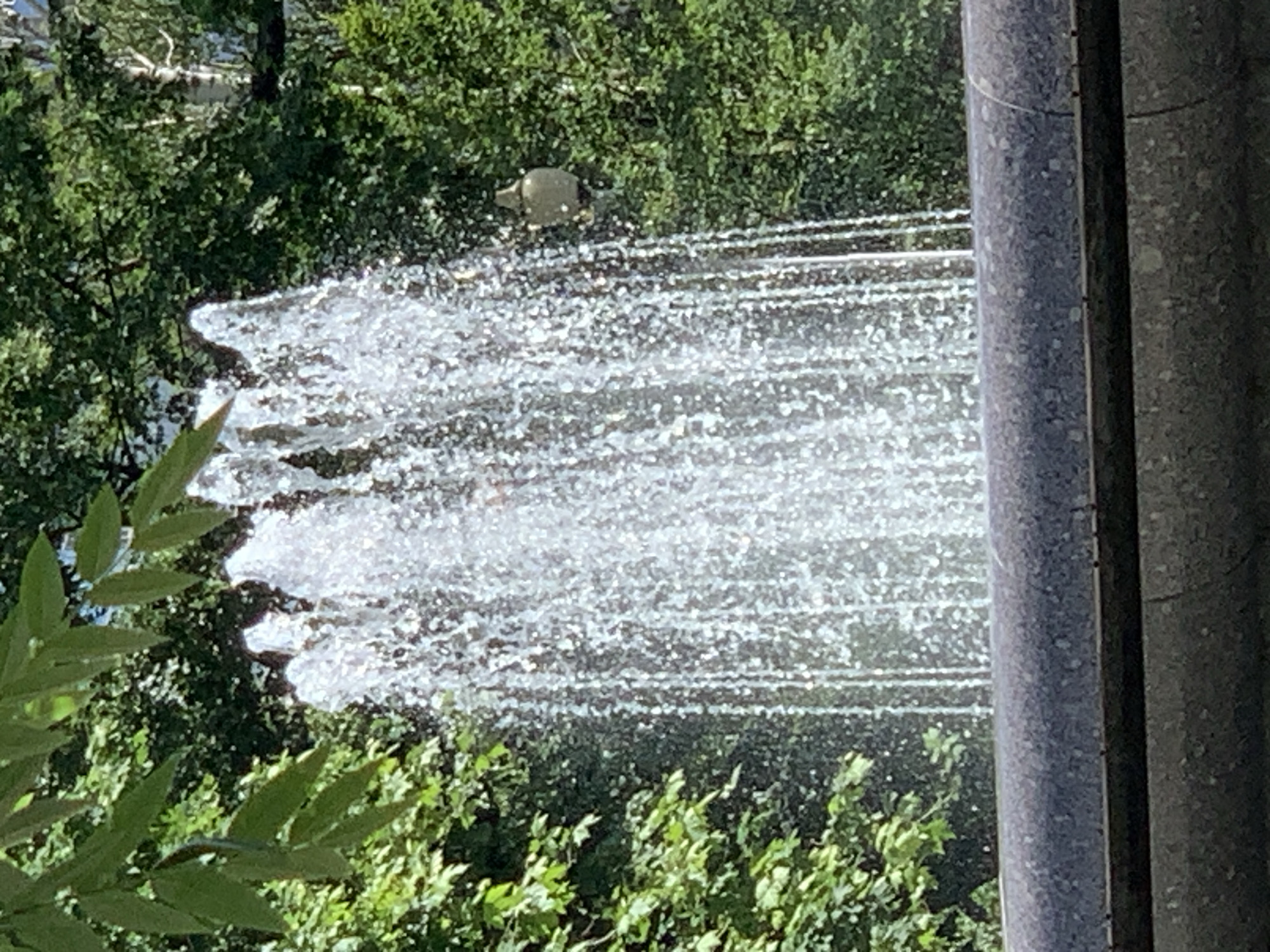 Pedestrians enjoy sunny afternoon at park fountain near Orthodox church