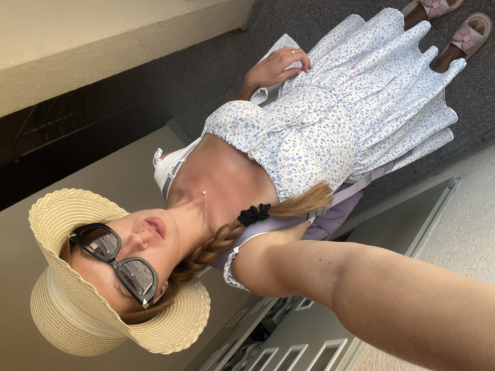 Selfie in a floral dress and straw hat outside a building