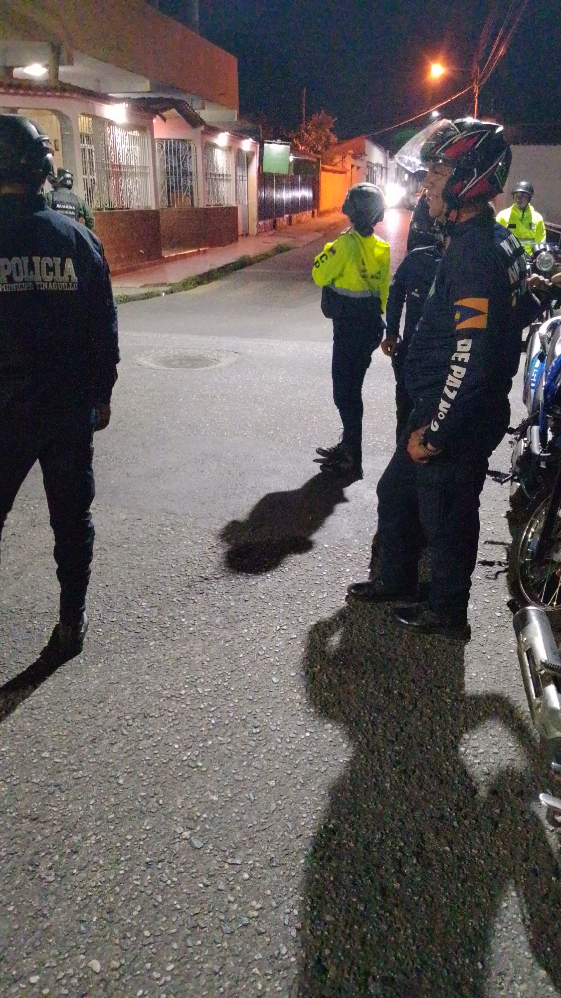 Uniformed personnel gather on Tinaquillo street at night