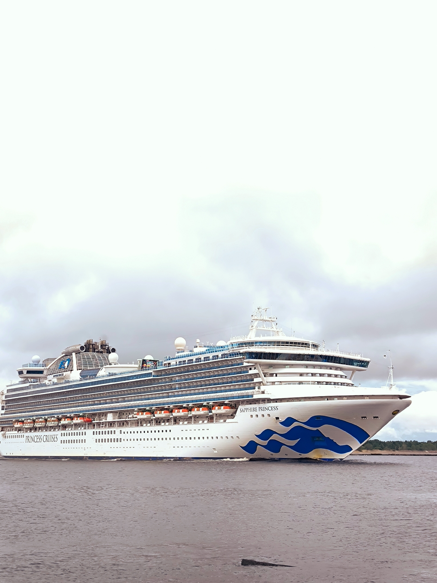 Sapphire Princess cruises past Vecāķi pier at dusk