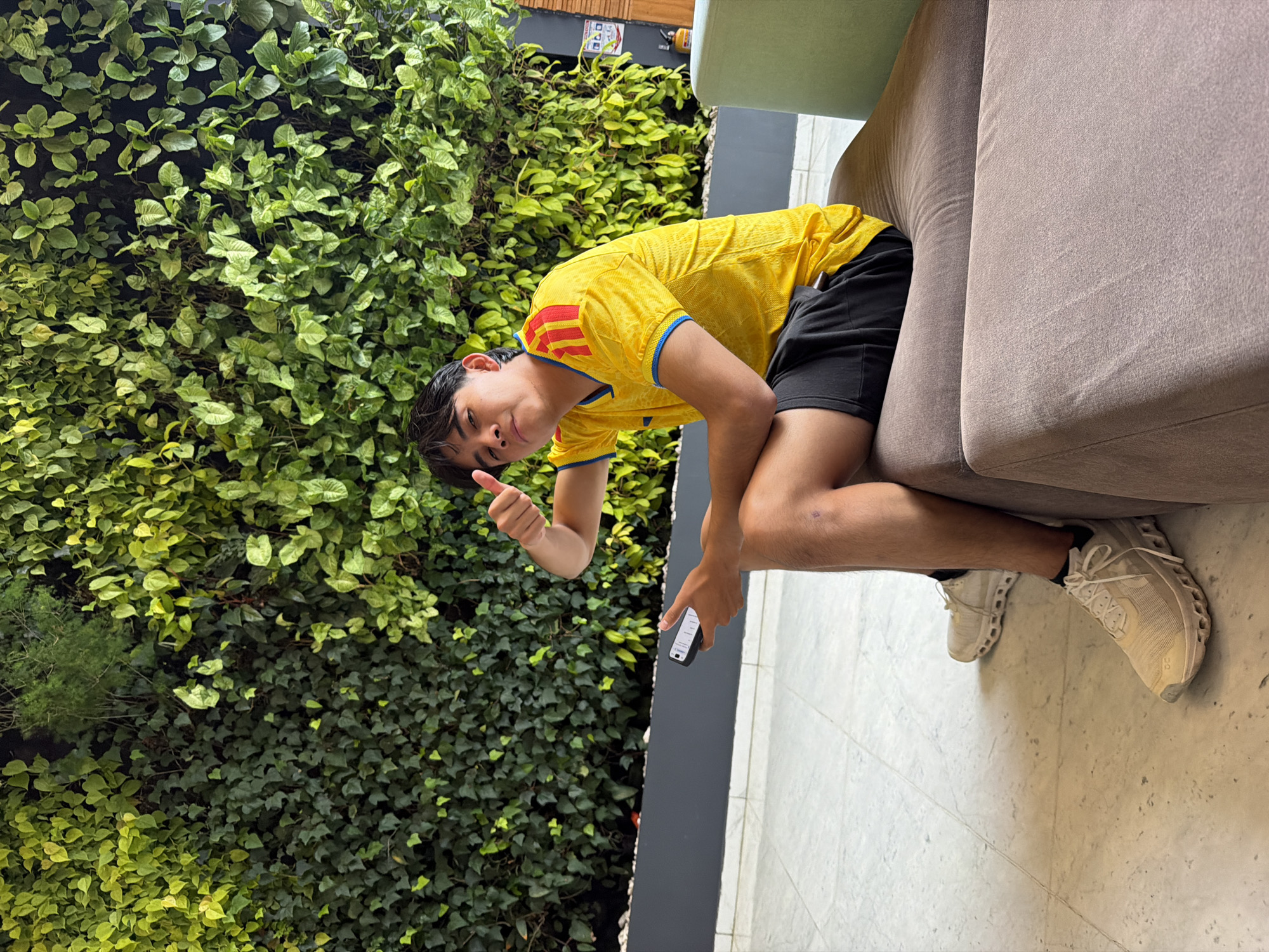 Person relaxes indoors, gives thumbs-up in Bogota residence