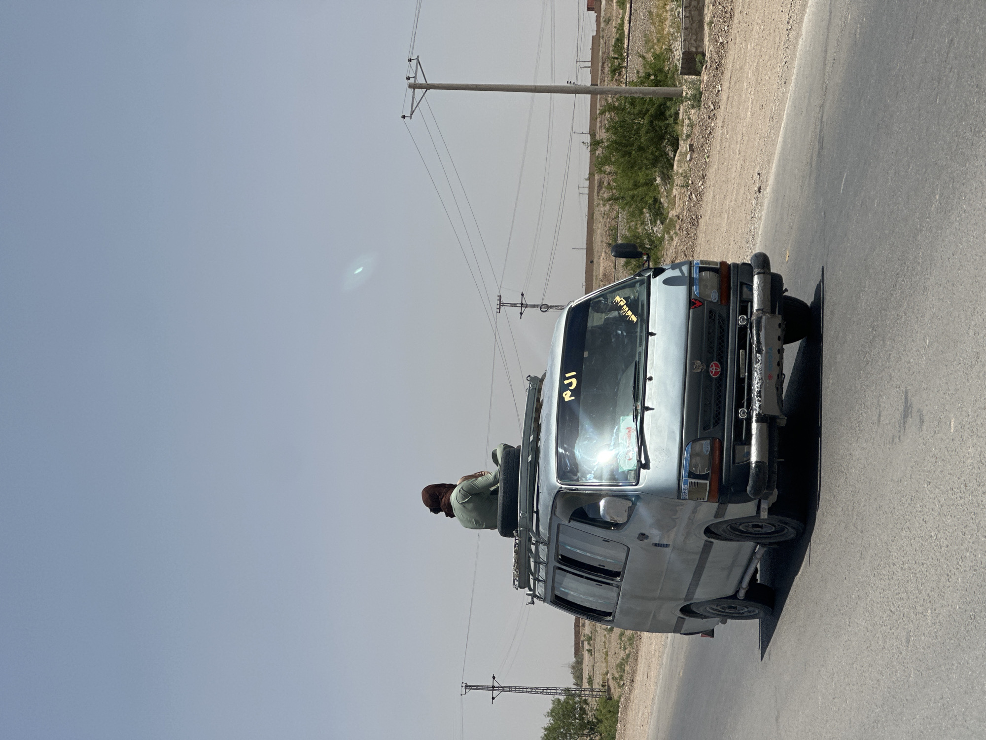 Van travels road in Yaru Karez under hazy morning sky