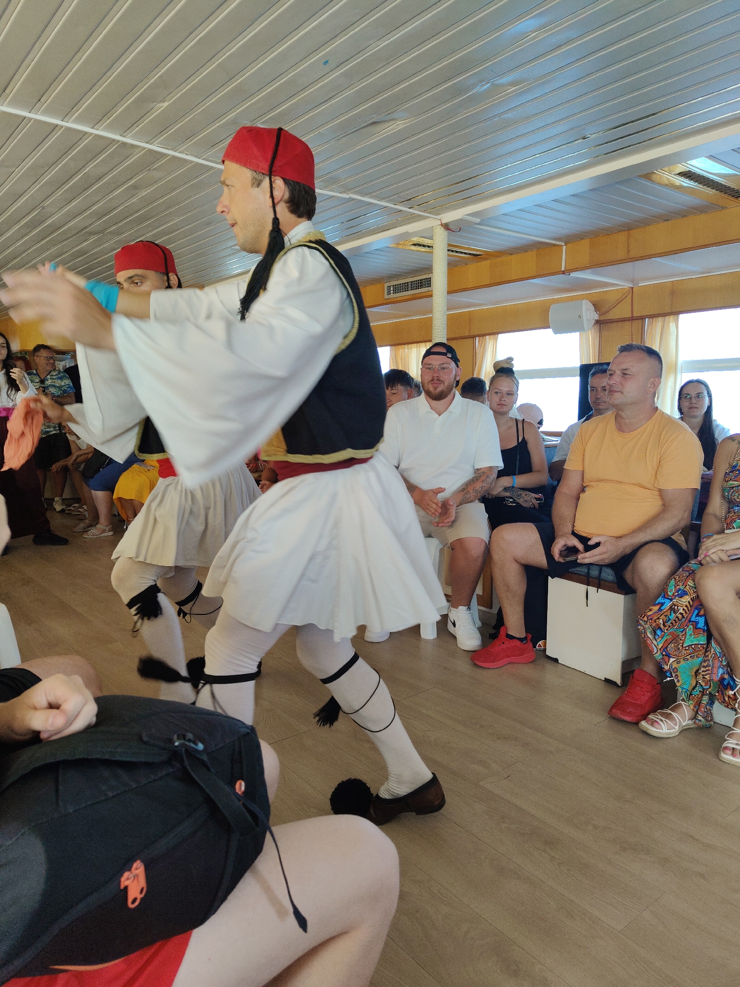 Traditional Greek folk dance performed indoors in full traditional costume