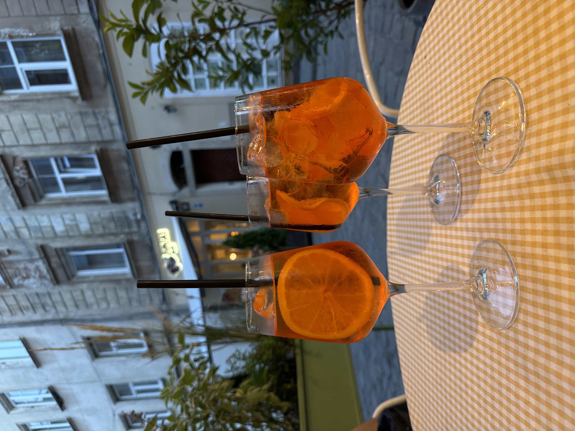 Aperol Spritzes at a cobblestone street café