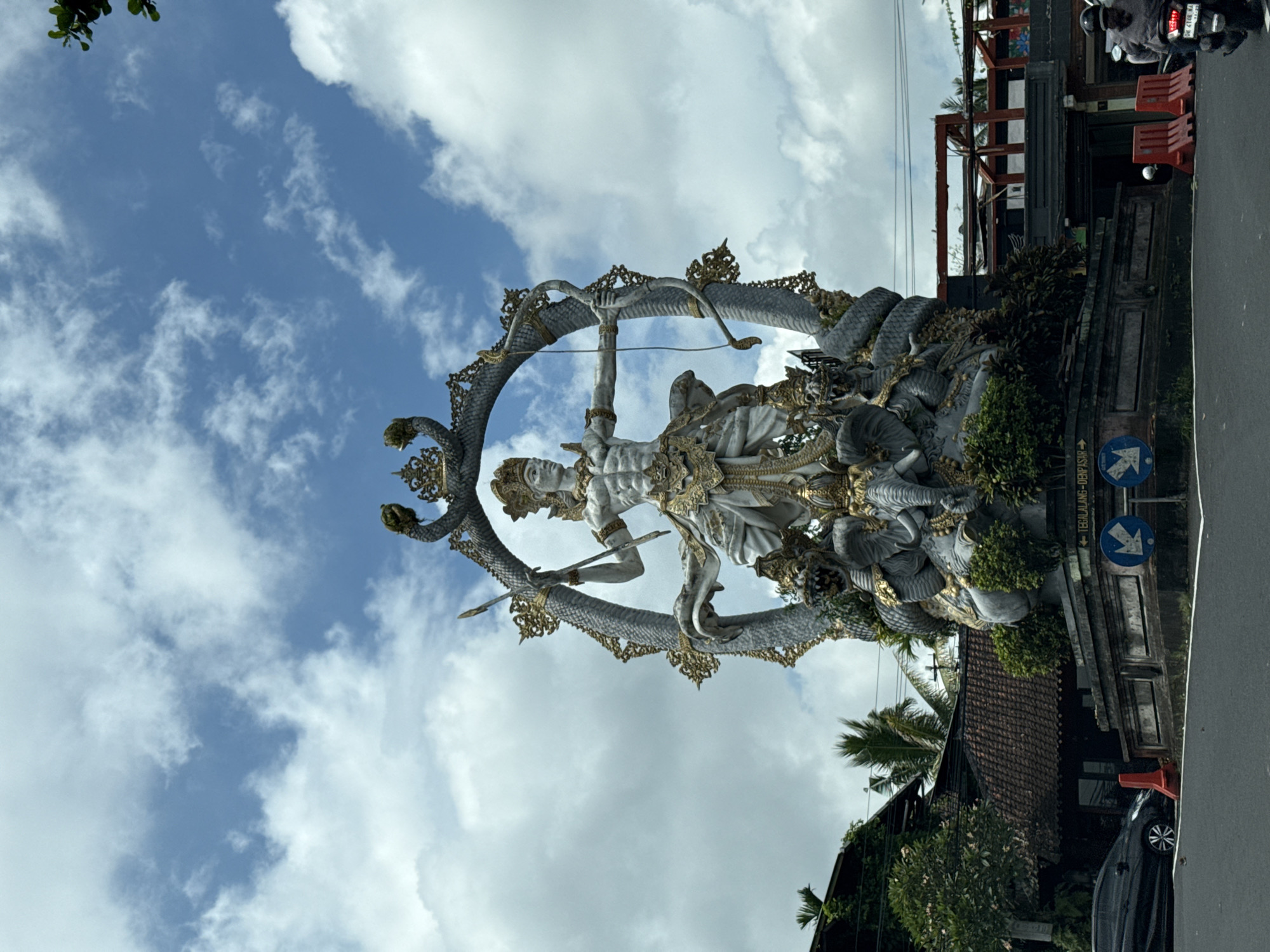 Balinese Hindu statue observed during daytime traffic in Ubud