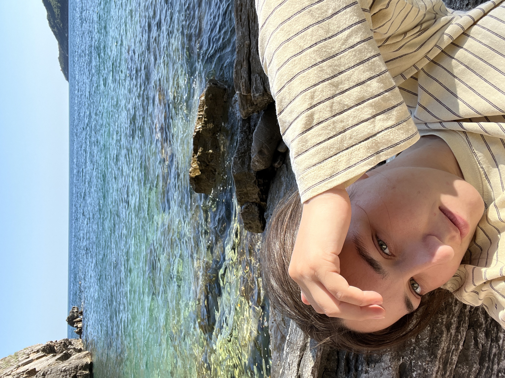Woman relaxes on rocky coastline in Budva, Montenegro